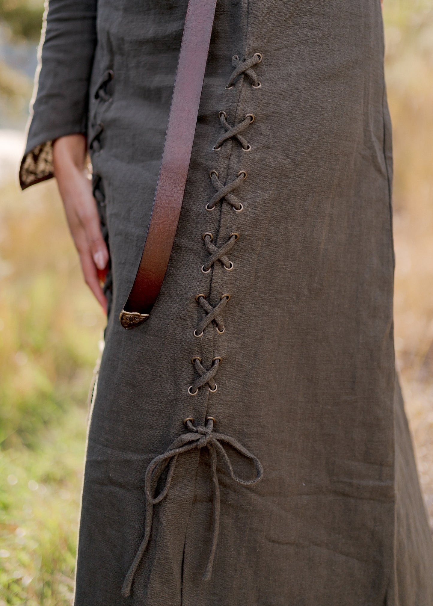 Olive Green Viking Dress with front lacing detail and leather belt shown against natural outdoor background
