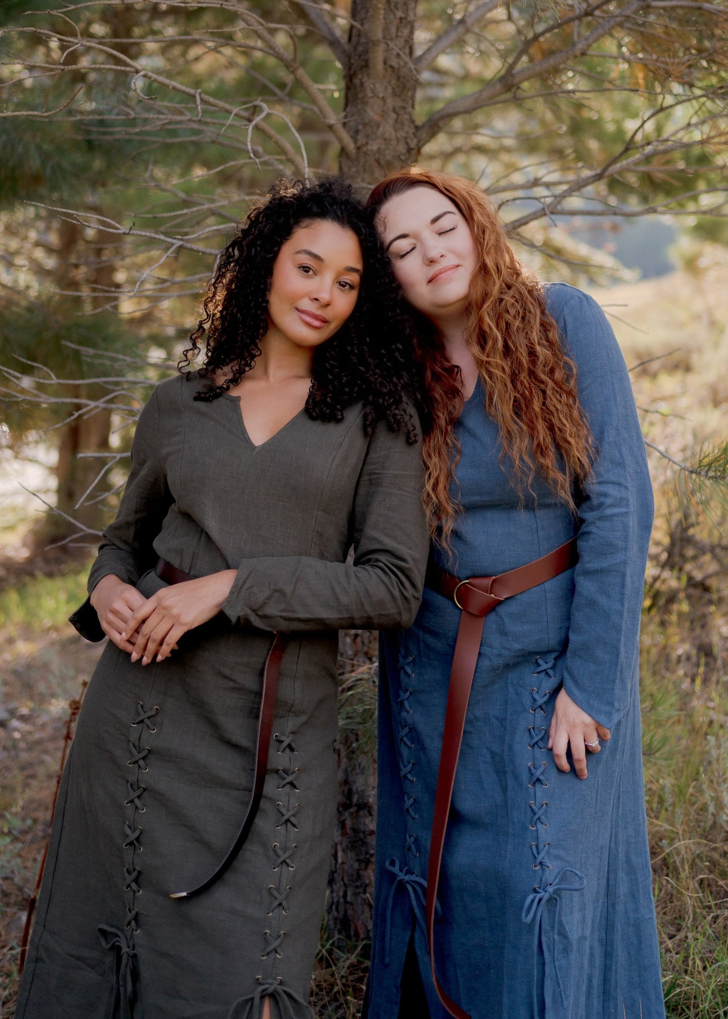 Olive Green Viking Dress shown outdoors with lace-up front detail and princess seams, modeled alongside blue medieval dress