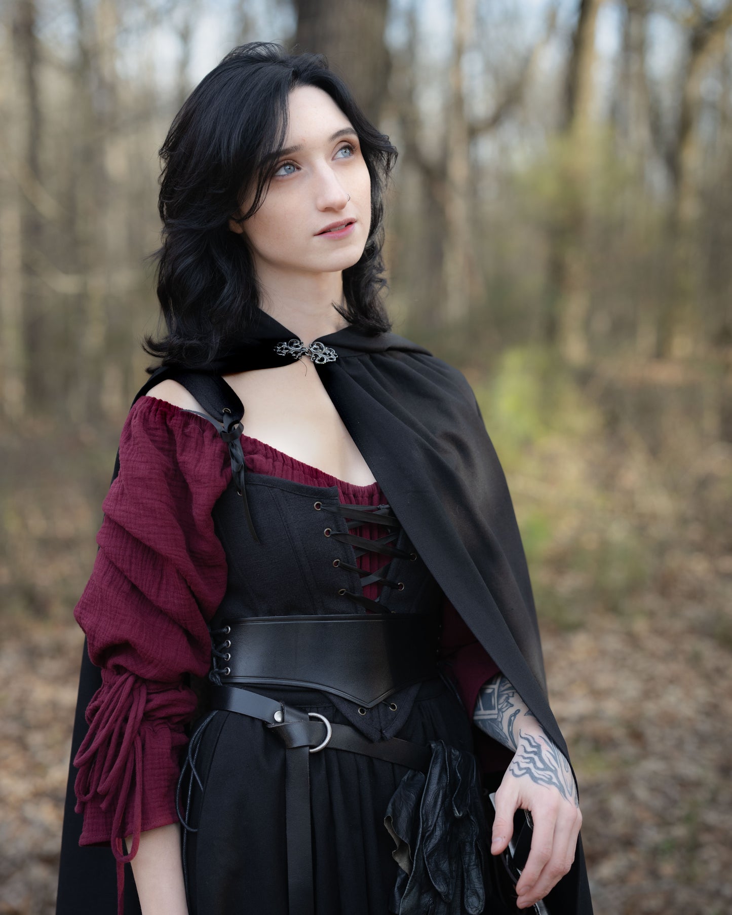 Black Cotton Corset Top styled with burgundy blouse and black cape in forest setting, showcasing gothic medieval fashion design