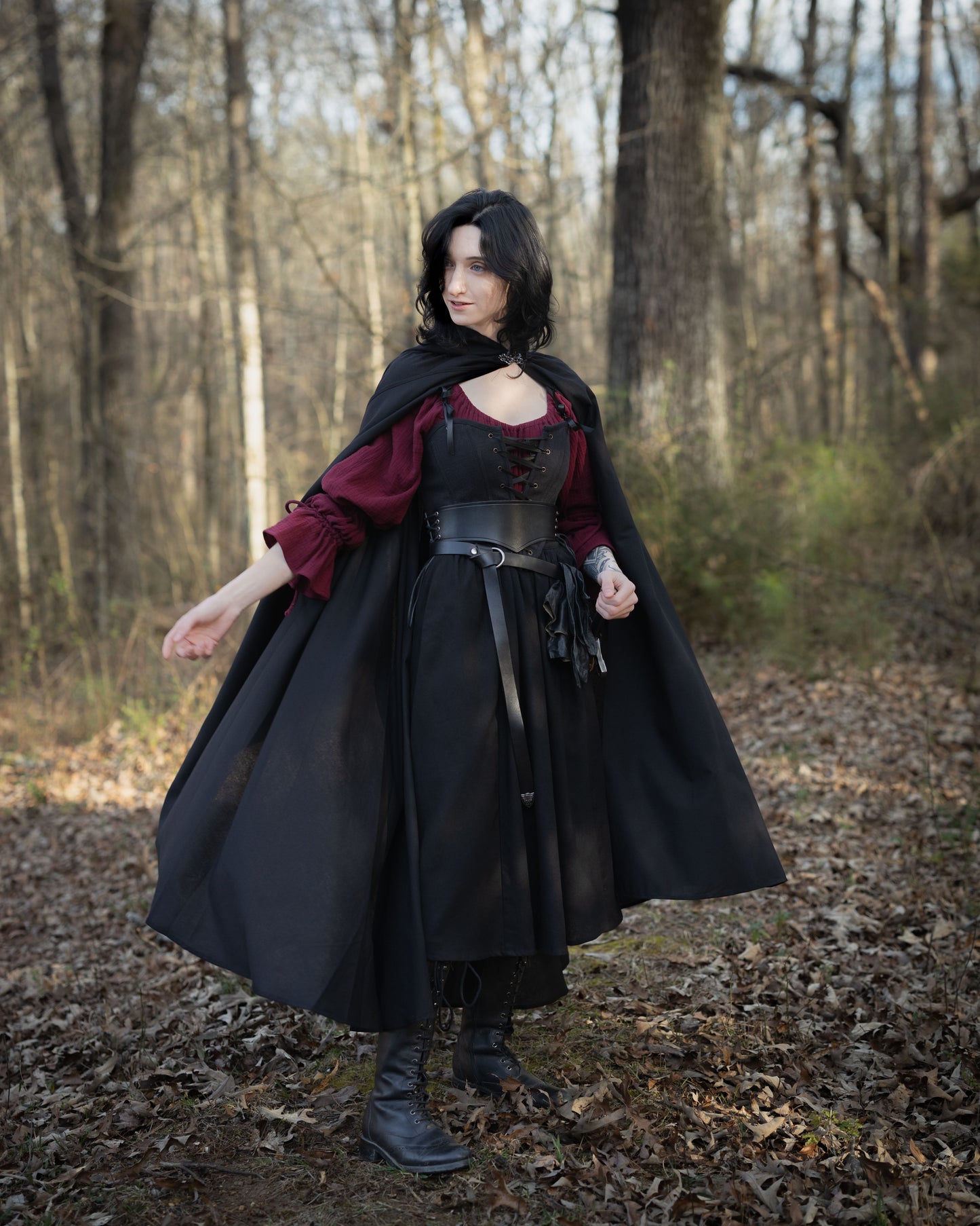 Black Cotton Corset Top styled in gothic fashion with flowing cape and burgundy blouse in woodland setting