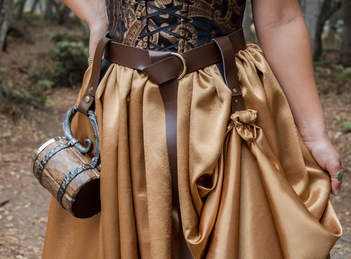 Brown vegan leather Renaissance belt with D-rings shown on a person wearing a gold skirt and patterned corset
