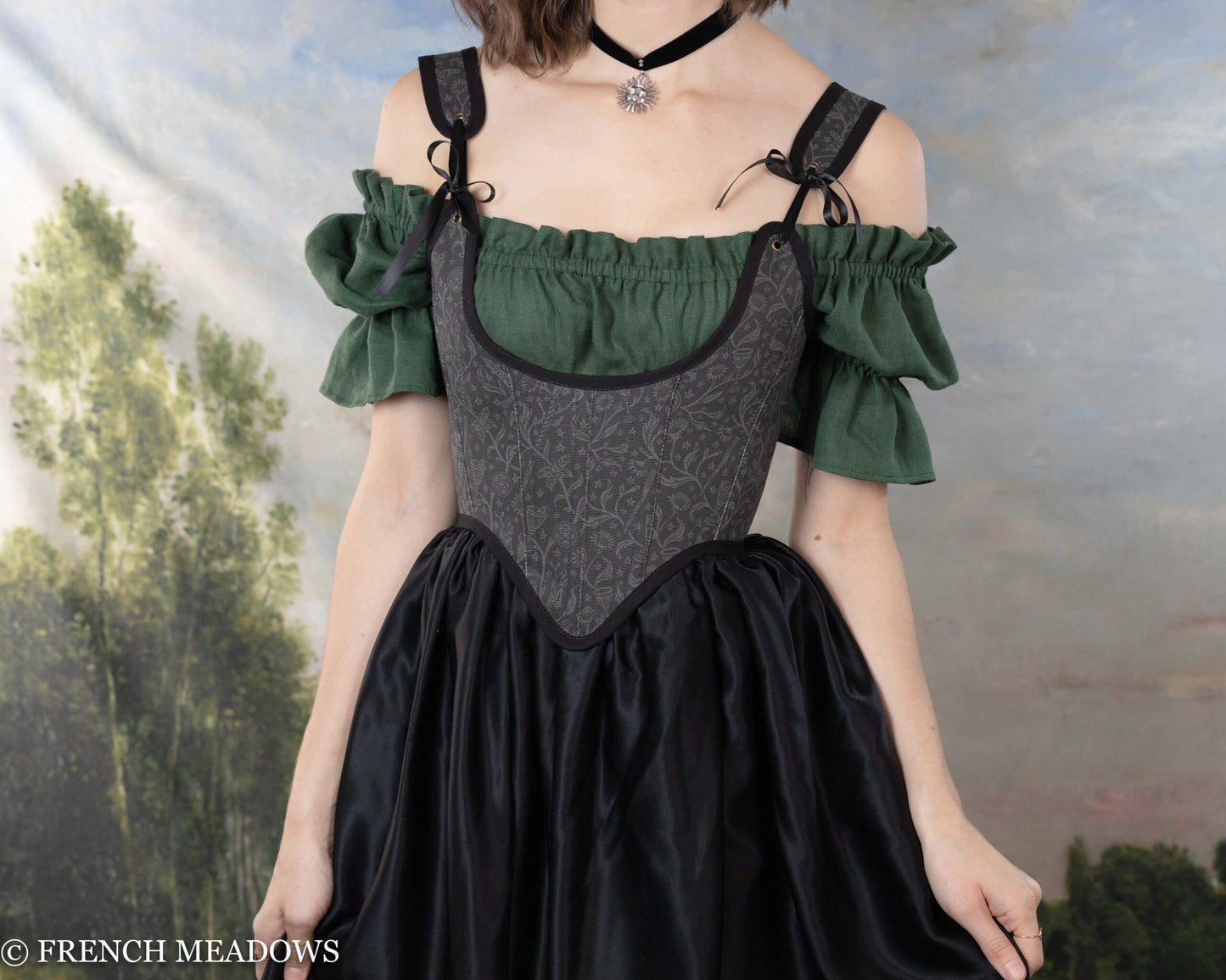 Black Tarot Underbust Bodice with green peasant sleeves shown on model against fantasy backdrop highlighting Victorian-inspired design