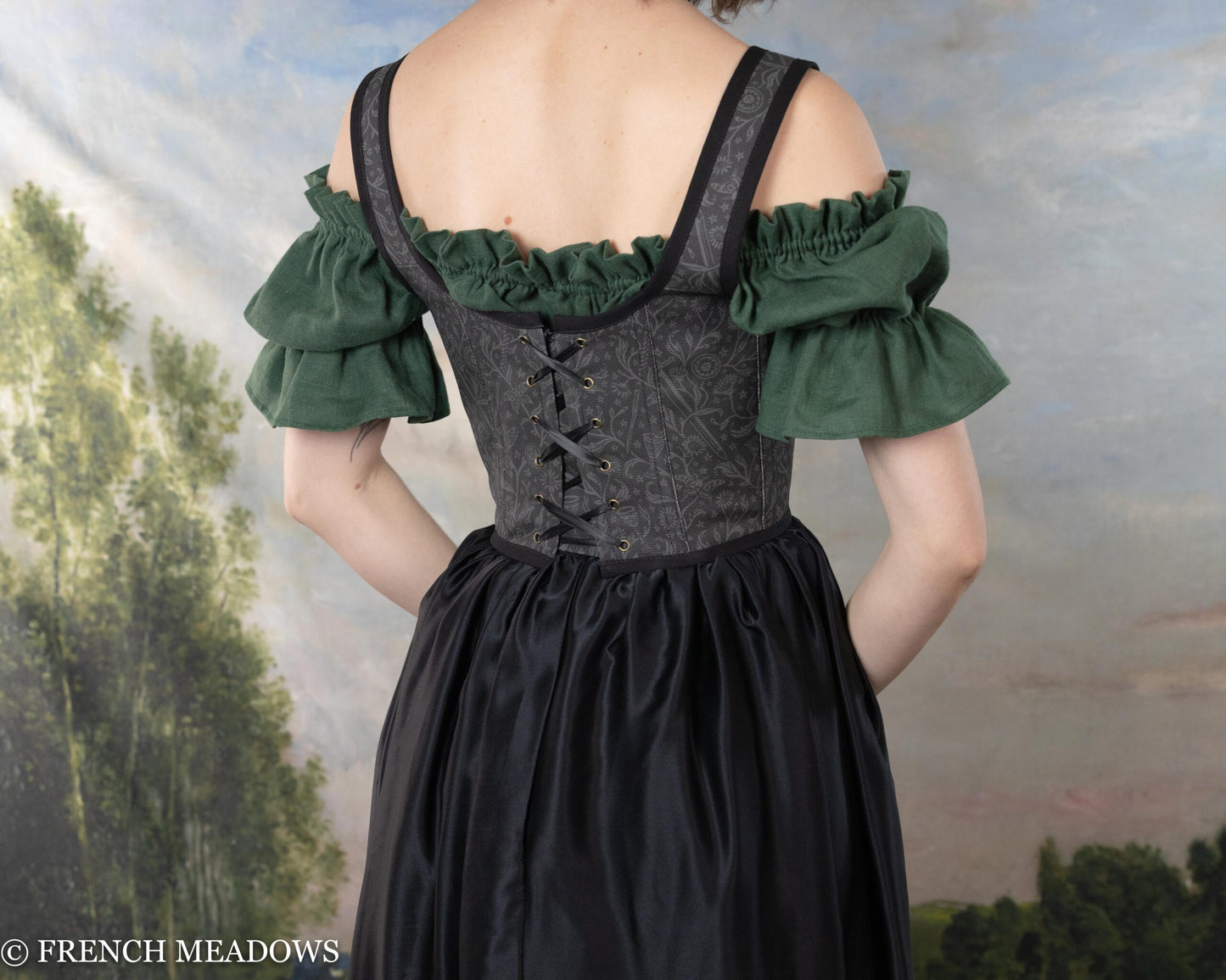 Handmade Black Tarot Underbust Bodice shown from back with green off-shoulder sleeves and lace-up closure against nature backdrop