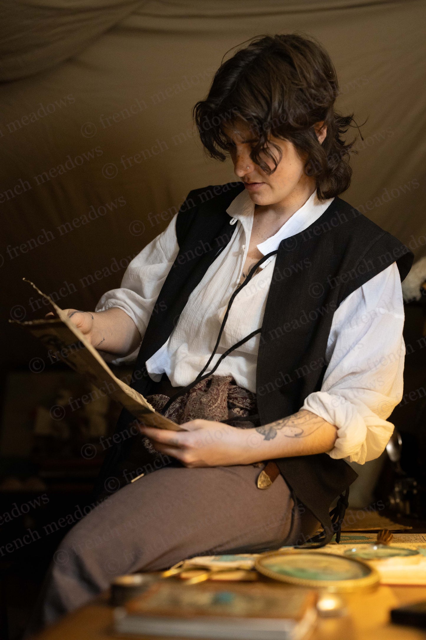 Black Bard Vest shown with white shirt and brown trousers in renaissance style, as person reads from parchment at desk