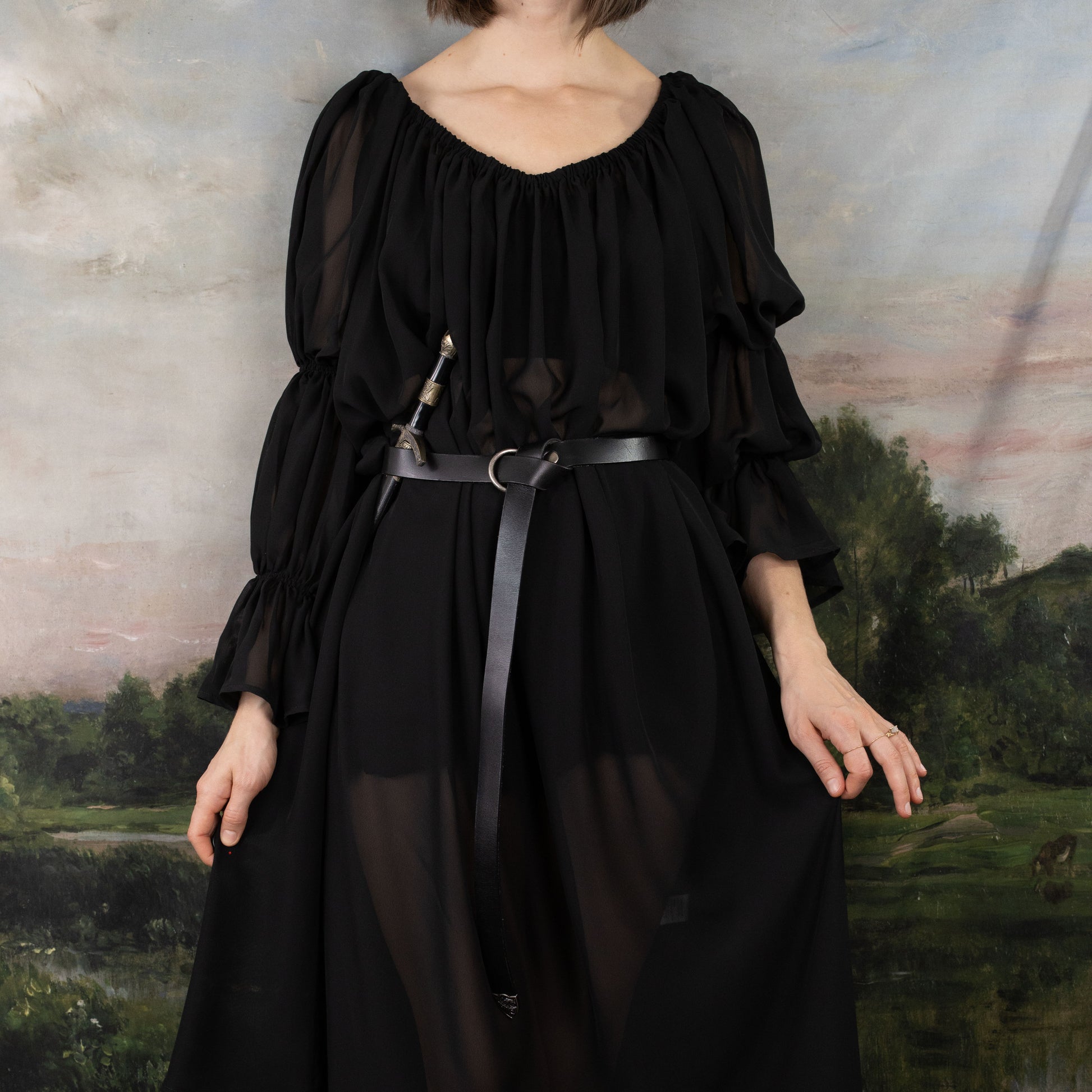 Black Chiffon Long Sleeve Chemise with ruffled sleeves and elastic neckline, belted at waist, shown against pastoral landscape