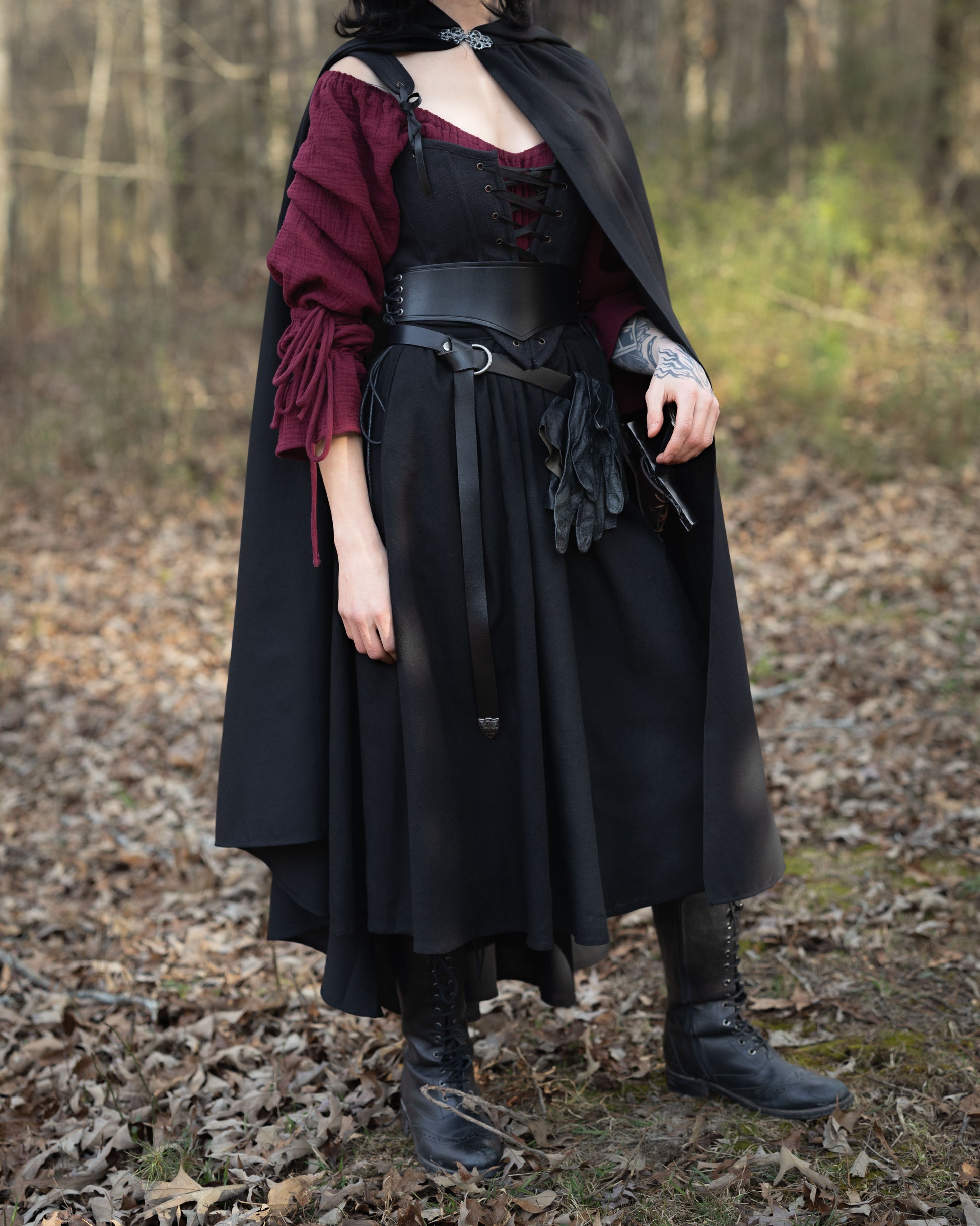 Black Cotton Midi Skirt styled with burgundy blouse and black cape in forest setting, showing medieval-inspired design