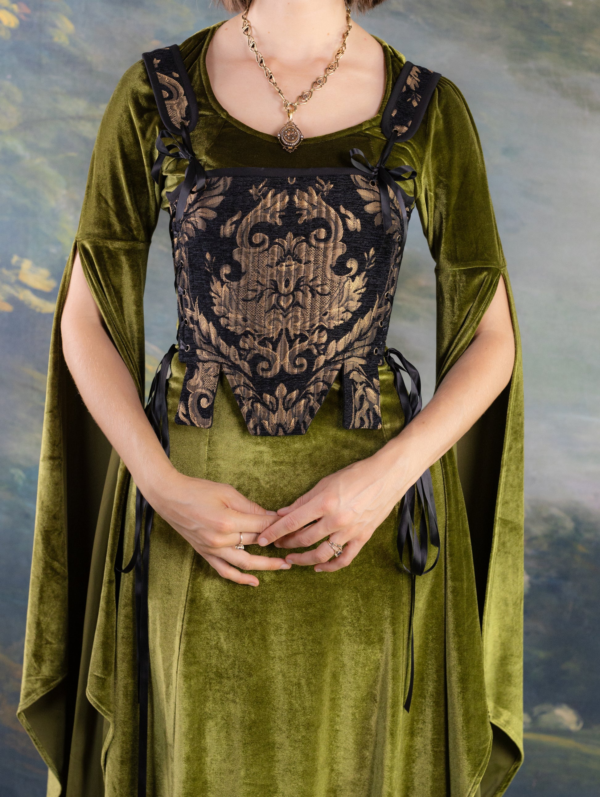 Black and gold chenille Tudor stays with intricate brocade pattern worn over olive green medieval dress