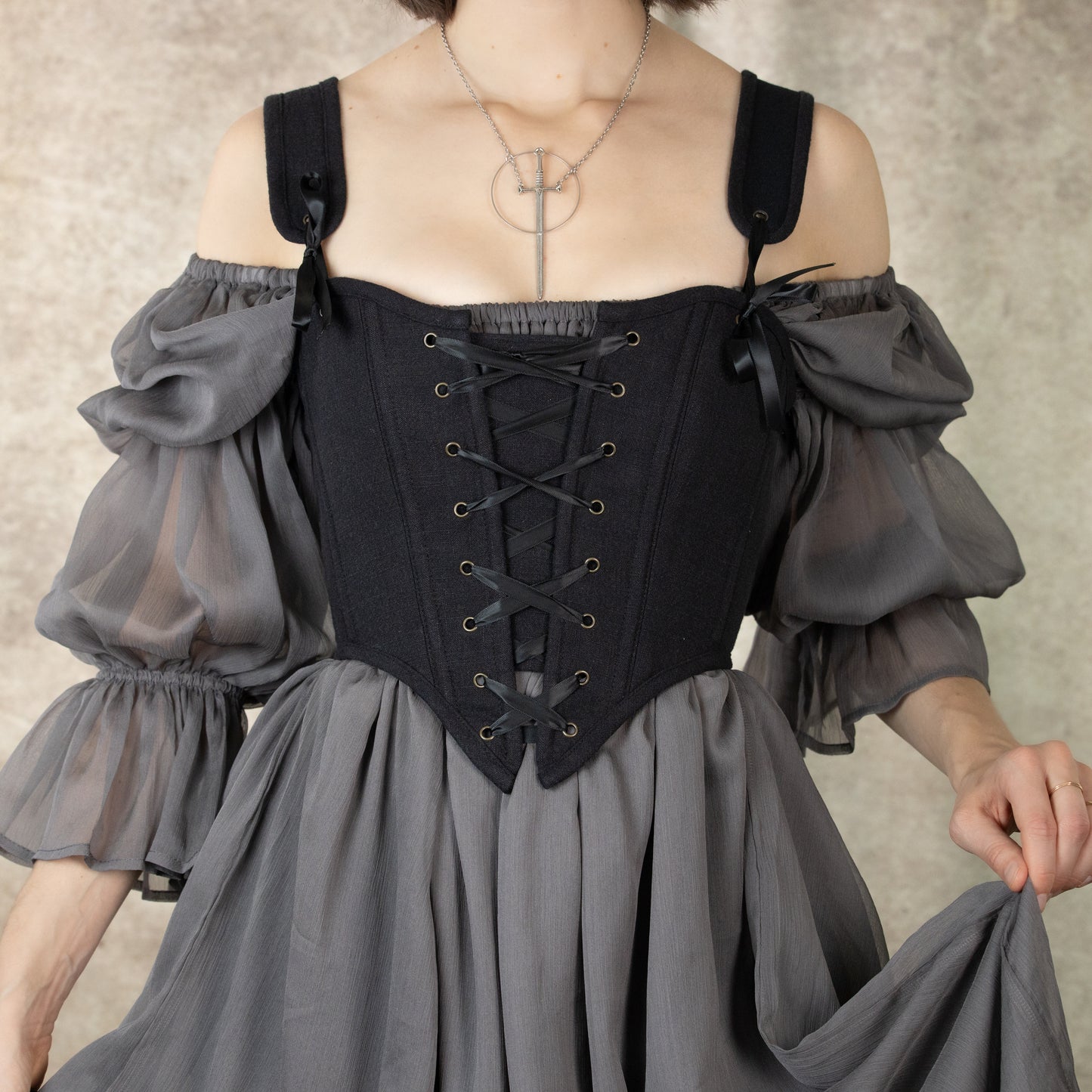 Black Cotton Corset Top with lace-up front detail and off-shoulder gray chiffon sleeves, styled with cross necklace