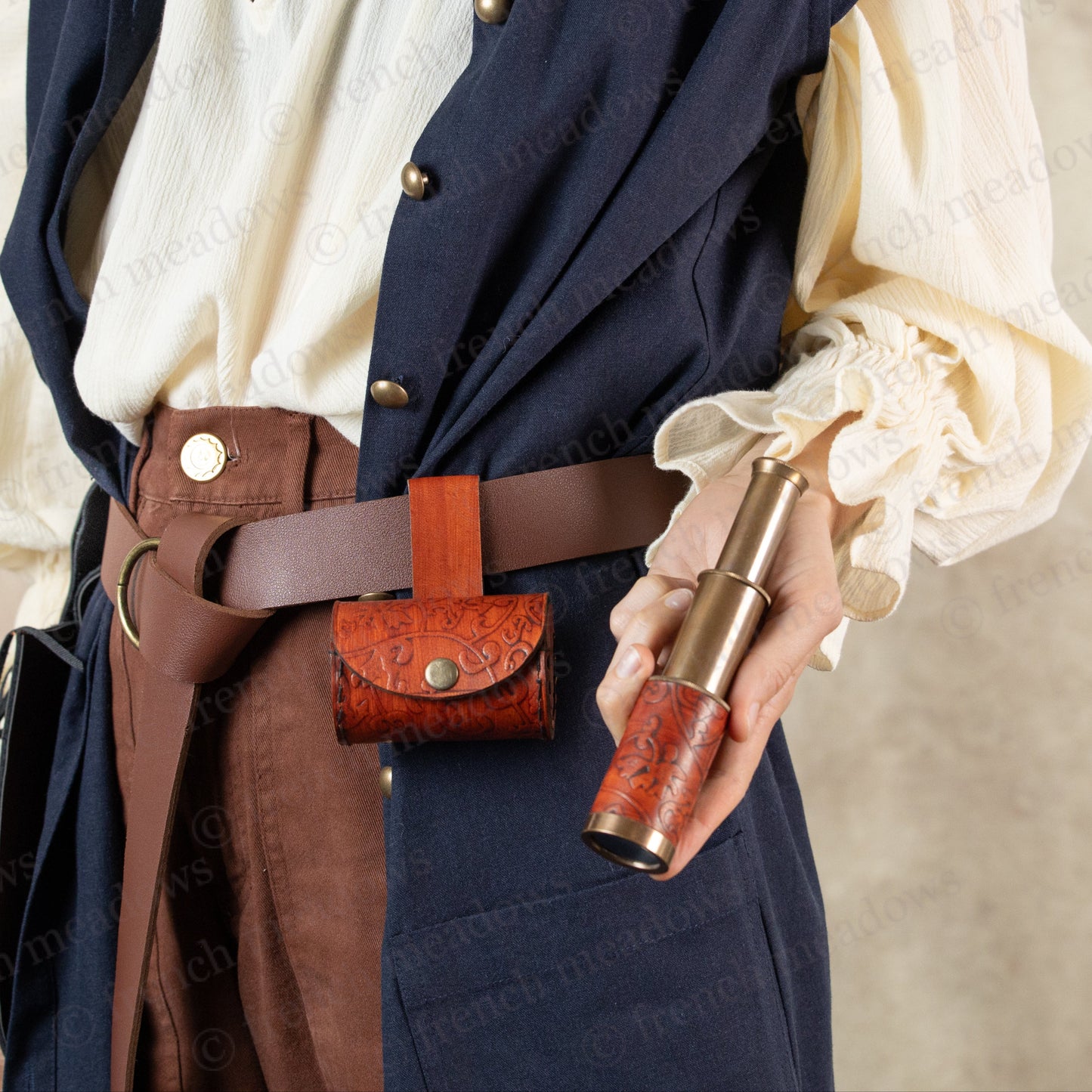 model dressed in pirate costume holding telescope in hand
