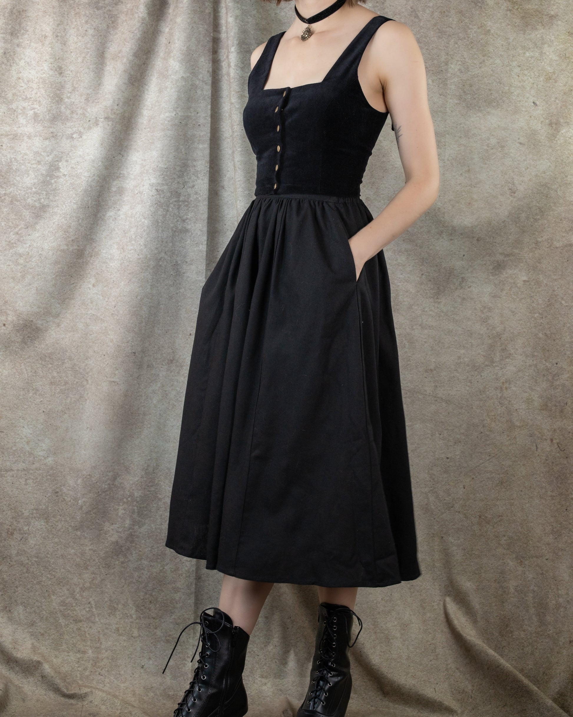Black Cotton Midi Skirt with fitted bodice and full gathered skirt featuring side pockets, shown with combat boots