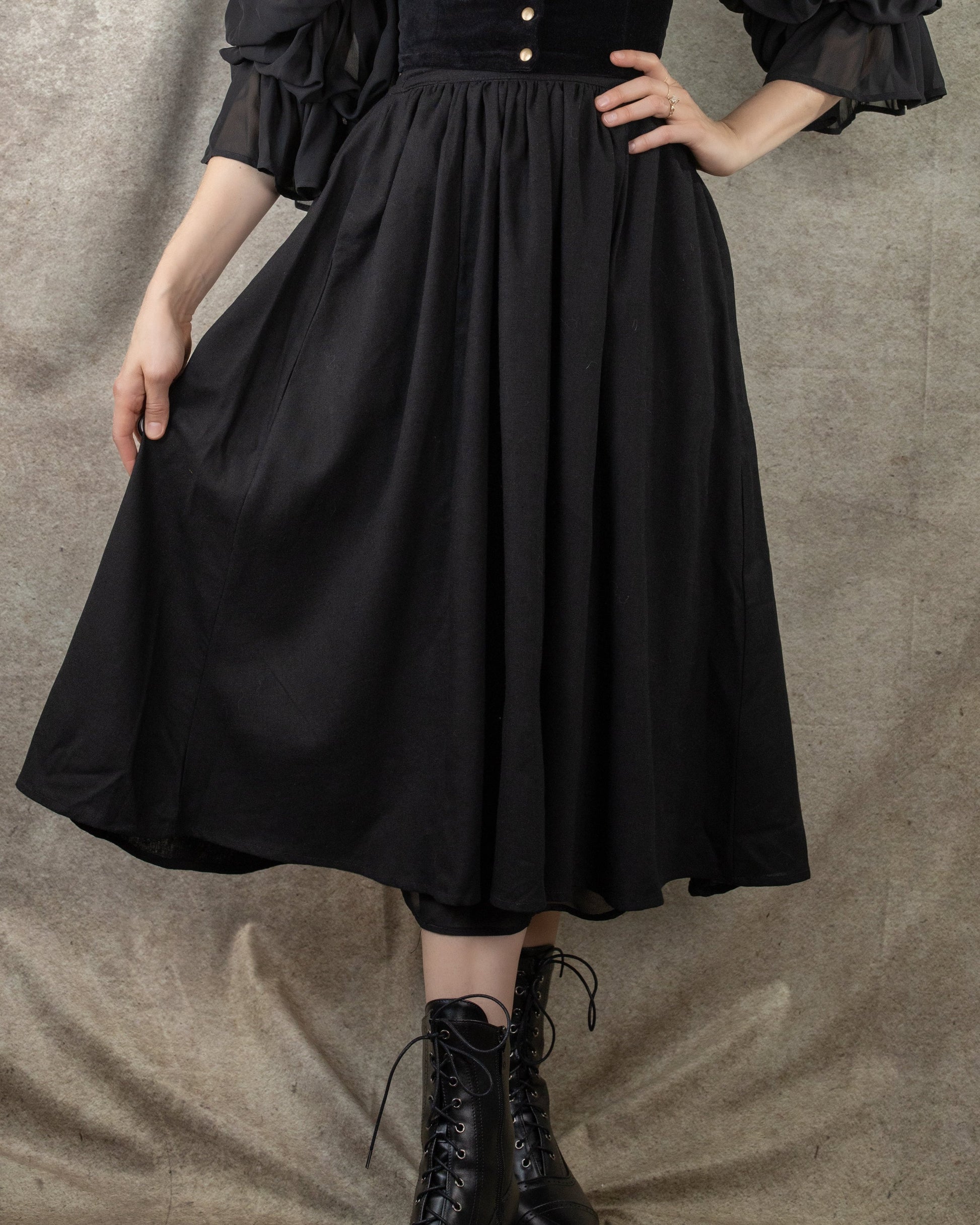 Black Cotton Midi Skirt: Flowing gathered skirt with elastic waistband shown with black lace-up boots and ruffled blouse