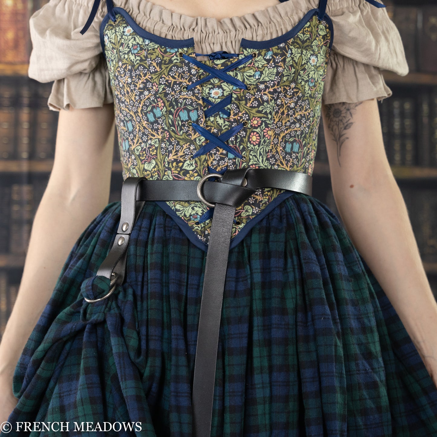 Leather Skirt Hikes shown on renaissance dress with floral bodice and plaid skirt, attached to black leather belt