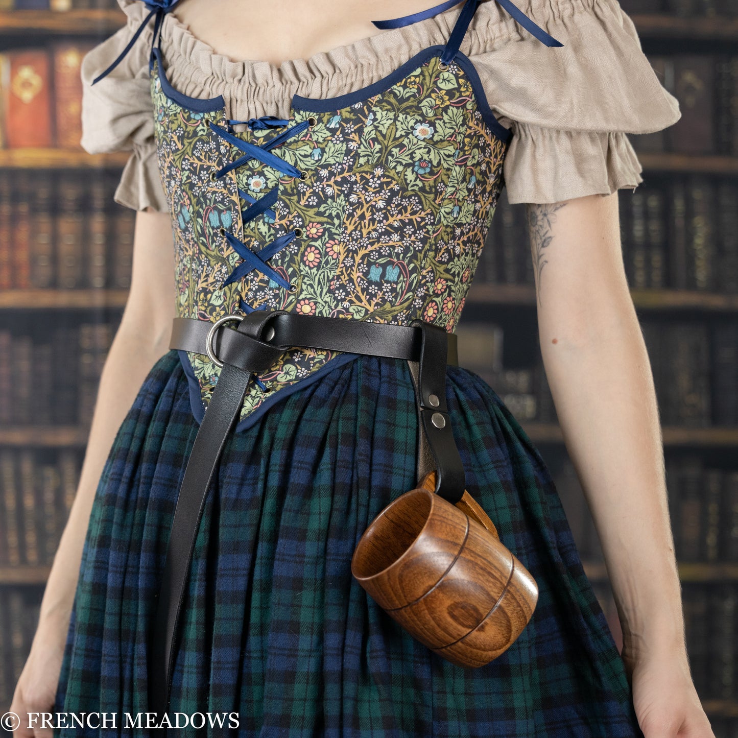 Leather tankard strap holding wooden mug on plaid dress with floral bodice and leather belt, perfect for Renaissance faire