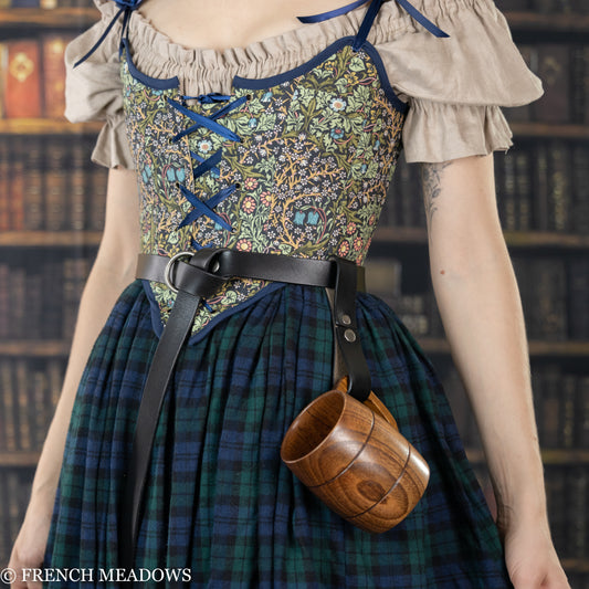 Leather tankard strap holding wooden mug on plaid dress with floral bodice and leather belt, perfect for Renaissance faire
