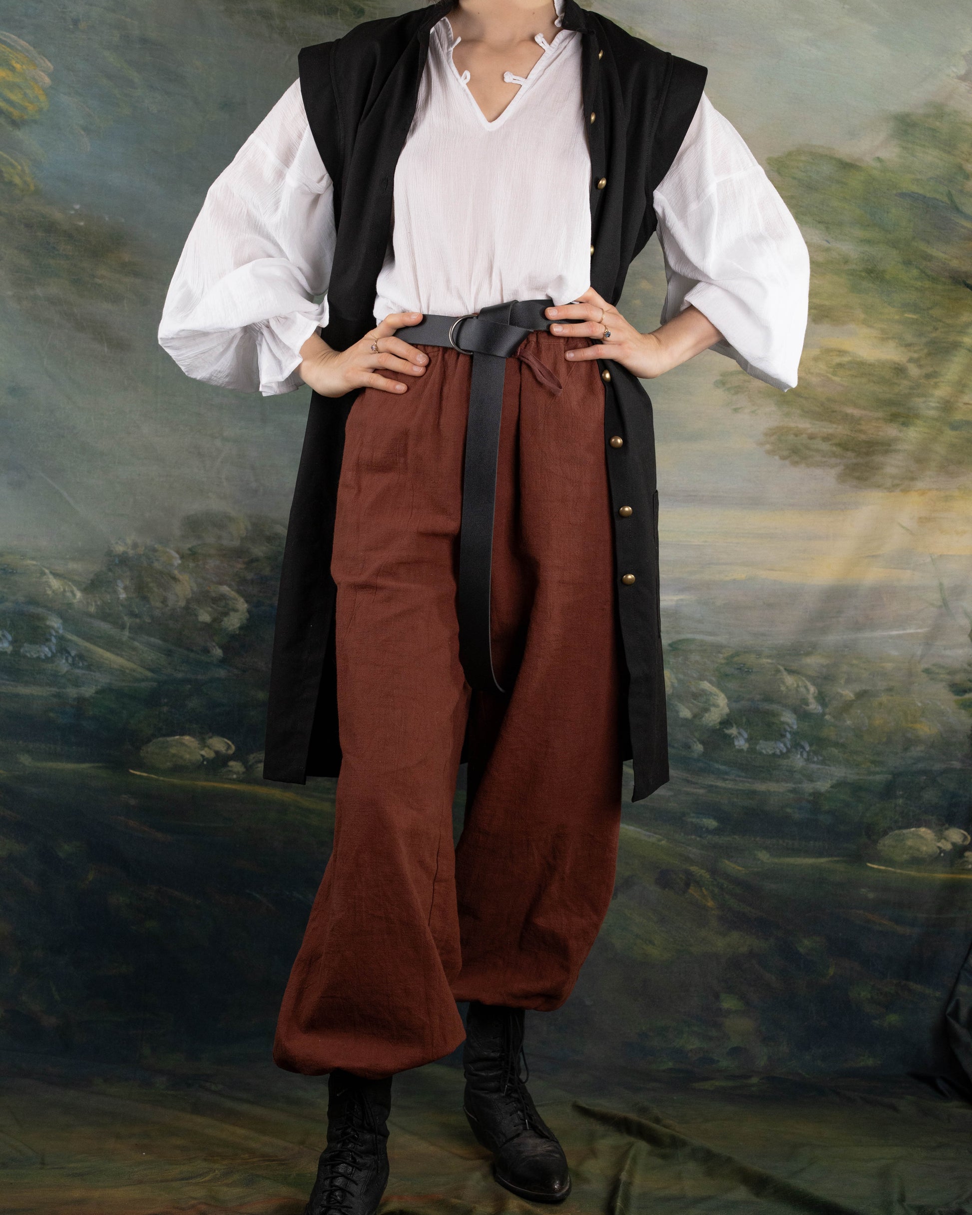 Black Pirate Vest over white shirt and brown pants styled for renaissance or pirate costume with leather waist belt.
