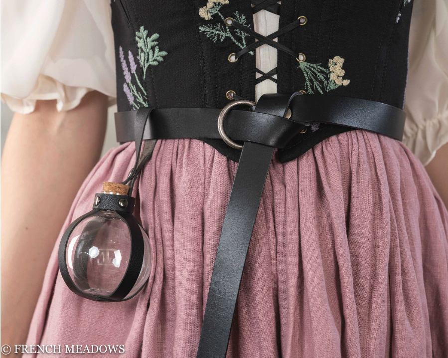 Potion bottle holder attached to black leather belt against floral corset and dusty pink renaissance skirt