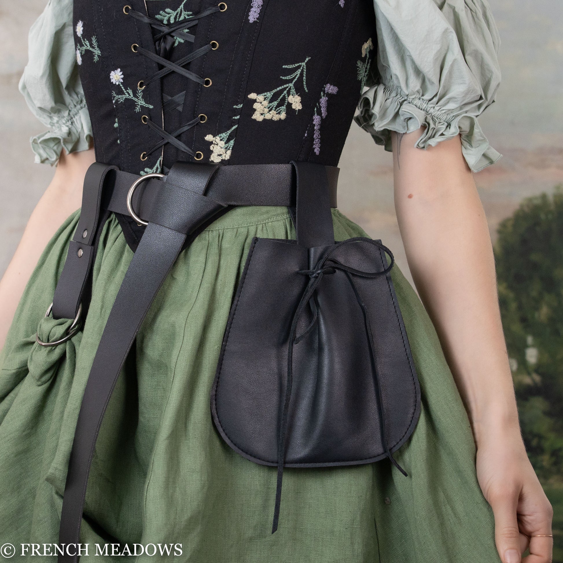 Black vegan leather drawstring pouch attached to belt, paired with floral corset and green renaissance dress