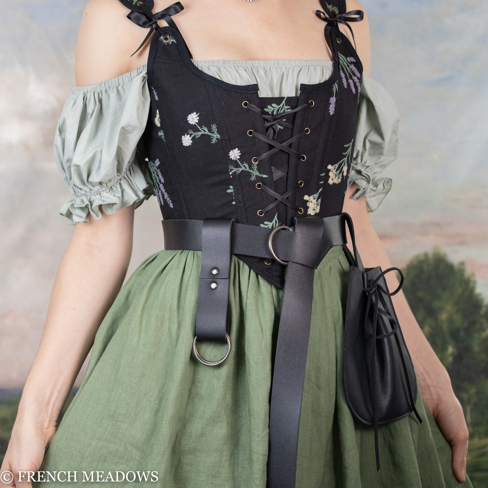 Black vegan leather skirt hikes shown on renaissance dress with corset and belt, displaying practical use for costume wear
