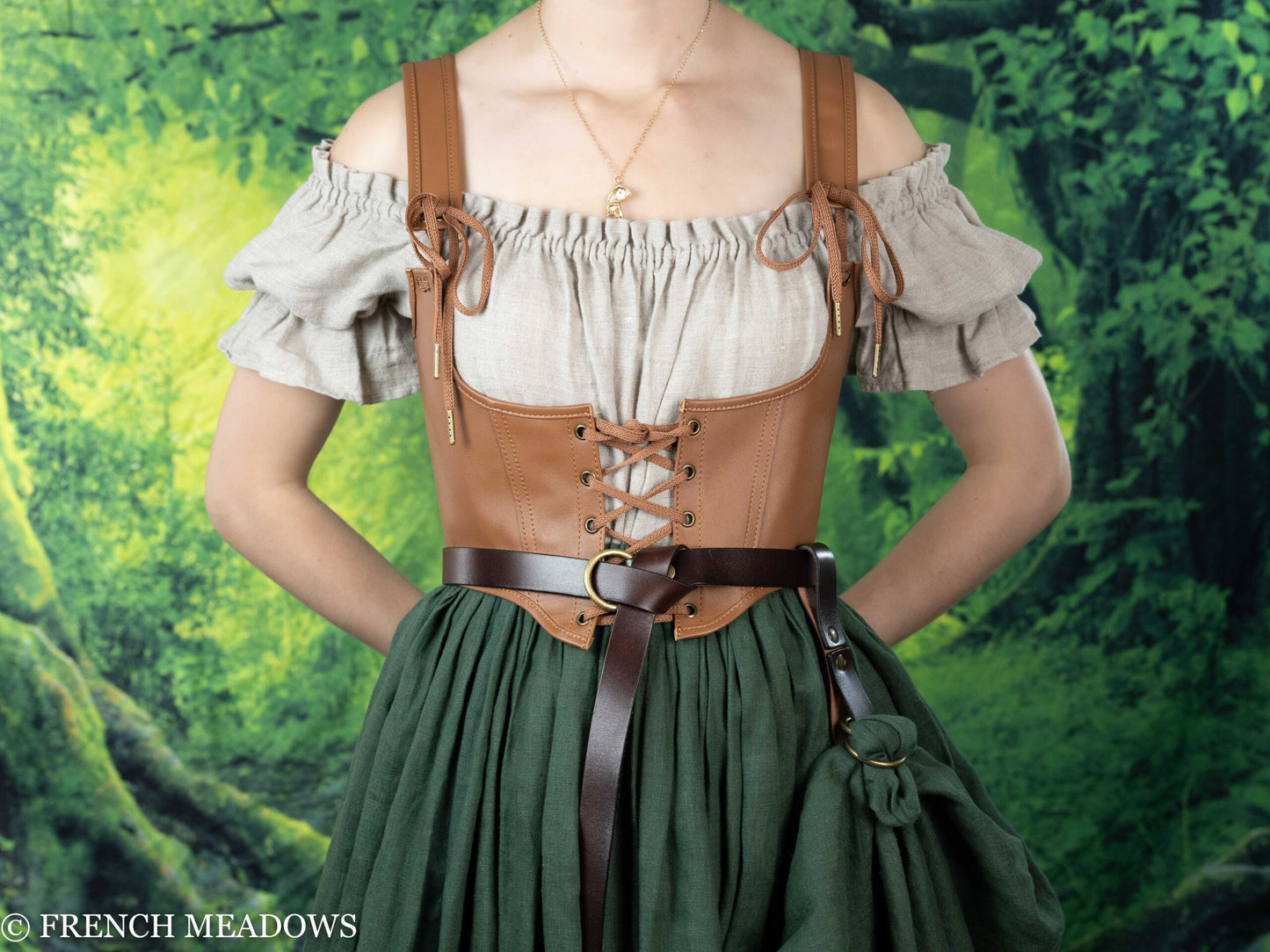 Leather underbust corset belt shown over peasant blouse and green dress, styled in Renaissance fashion against forest backdrop