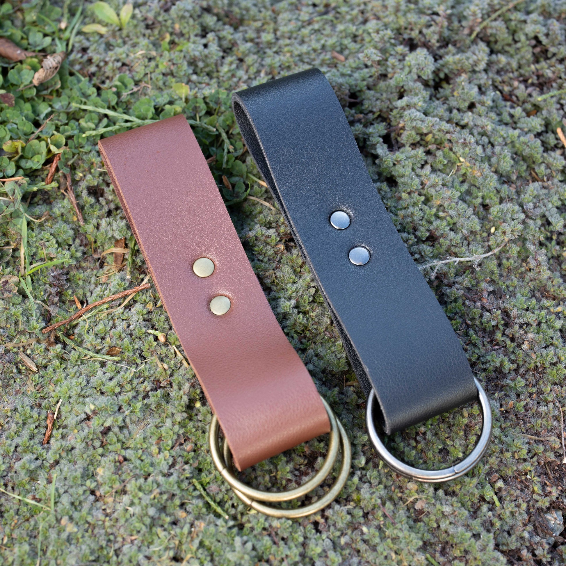 Vegan leather skirt hikes in brown and black with metal D-rings displayed on mossy ground, medieval costume accessories