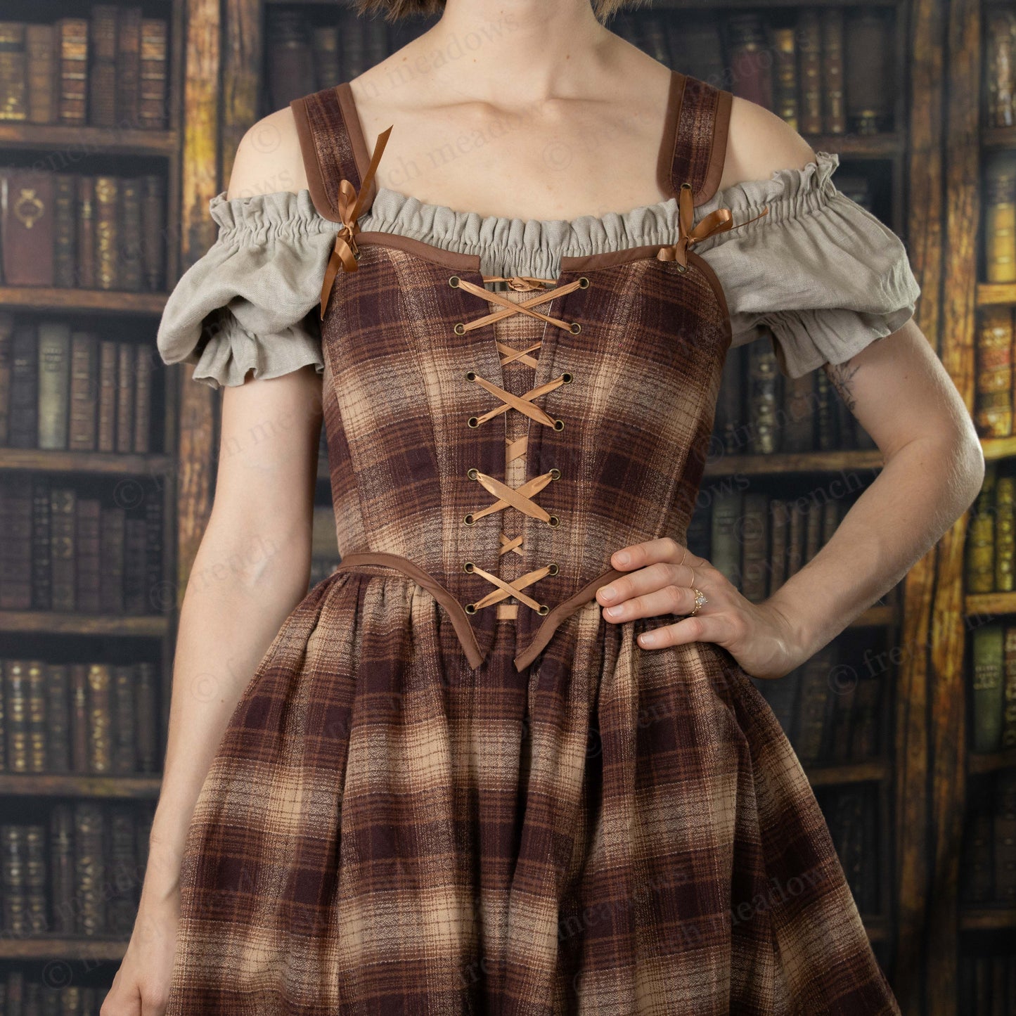 Brown Plaid Corset Top with off-shoulder white sleeves and leather straps, lace-up front detail against library backdrop