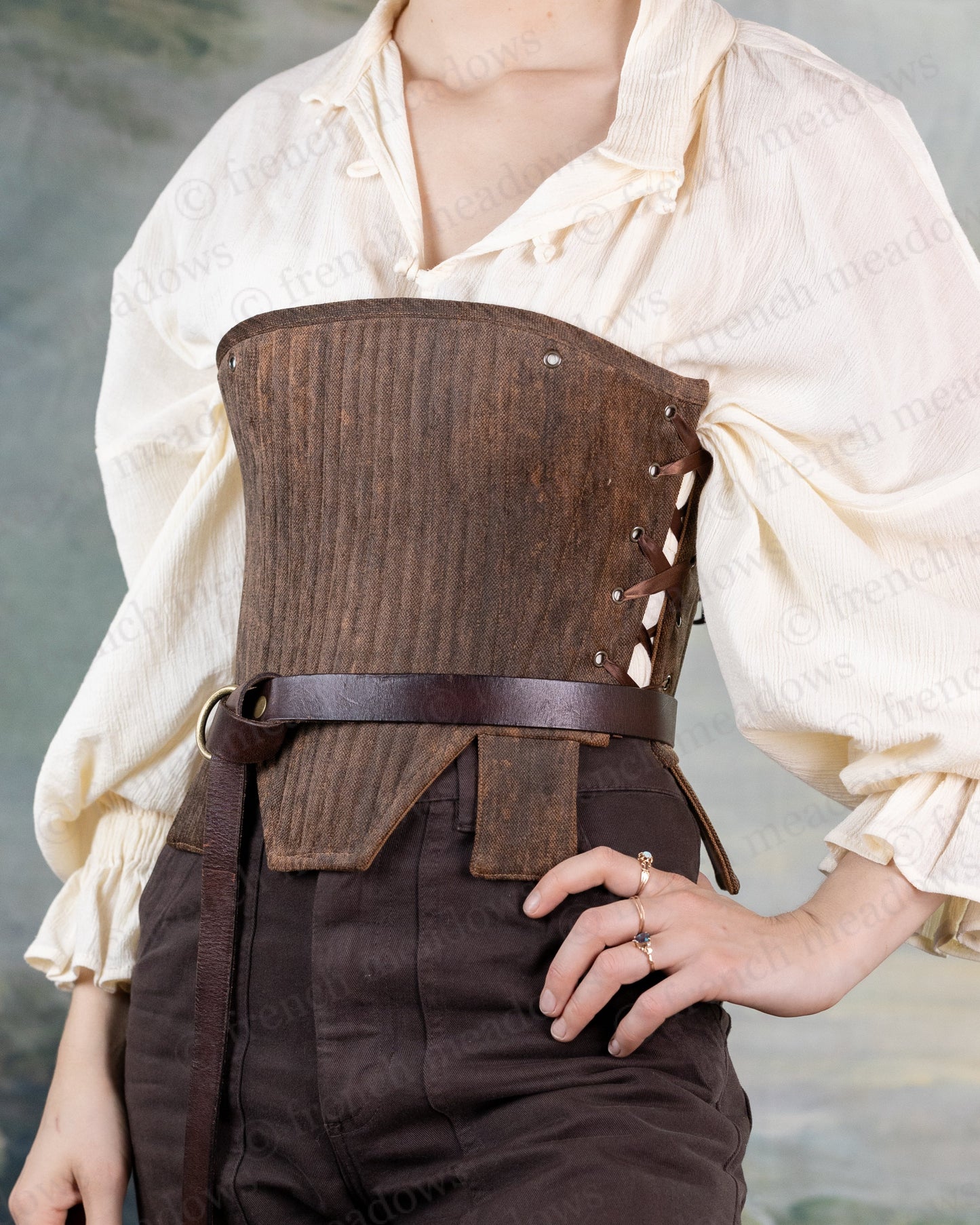 Brown Tabbed Tudor Stays shown with cream colored shirt, featuring side lacing, ornamental waist tabs and structured boning design