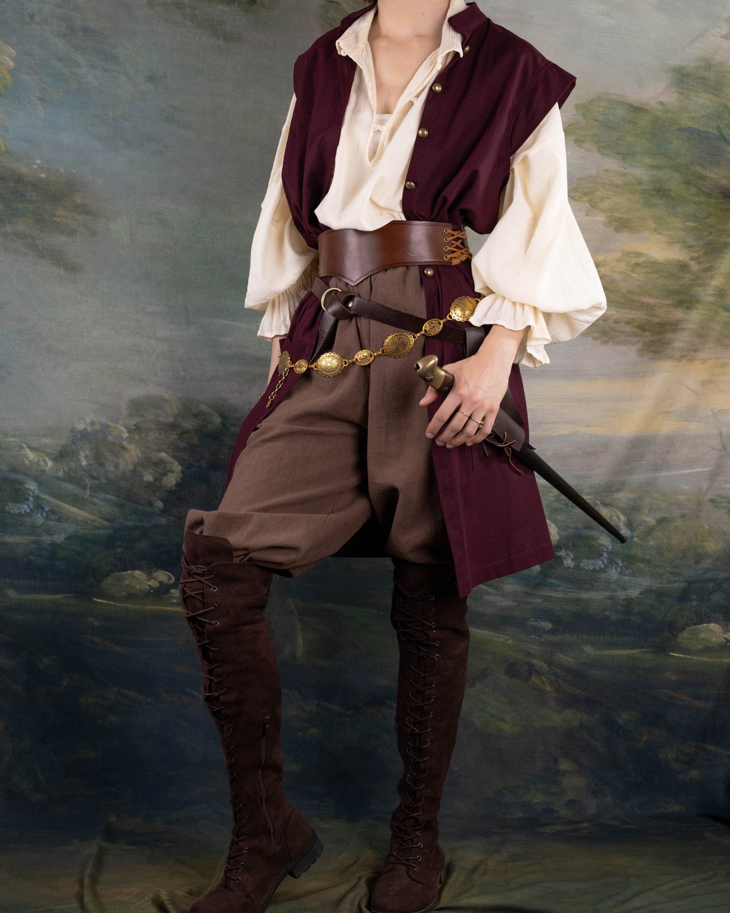 Burgundy Pirate Vest worn over a cream Darcy Shirt with leather belt and medieval-style brown pants and boots.