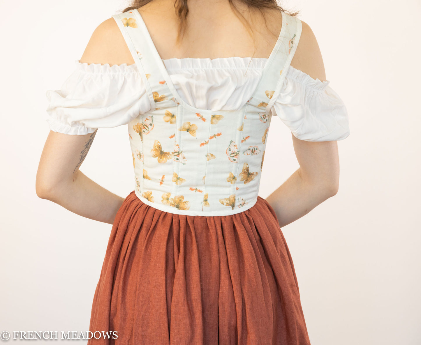 Handmade Butterfly Linen Renaissance Bodice shown from back view with off-shoulder white blouse and rust-colored skirt