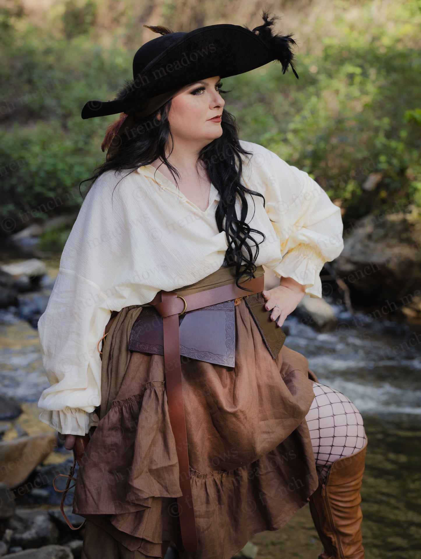 Debossed leather underbust corset shown in medieval-inspired outfit with ruffled dress and period accessories by stream