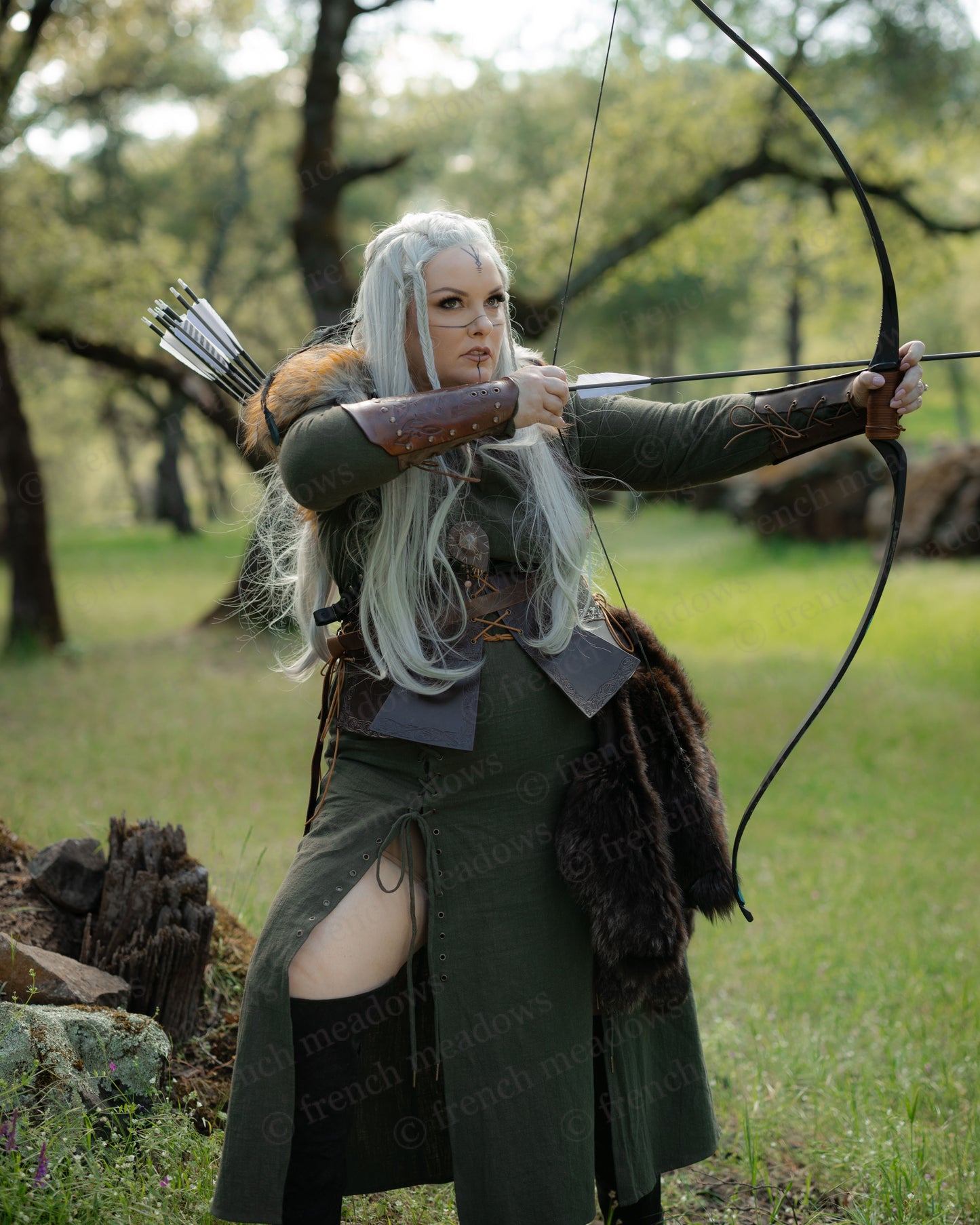Olive Green Viking Dress worn by archer with bow, featuring laced slit, fitted silhouette, and medieval style outdoors.