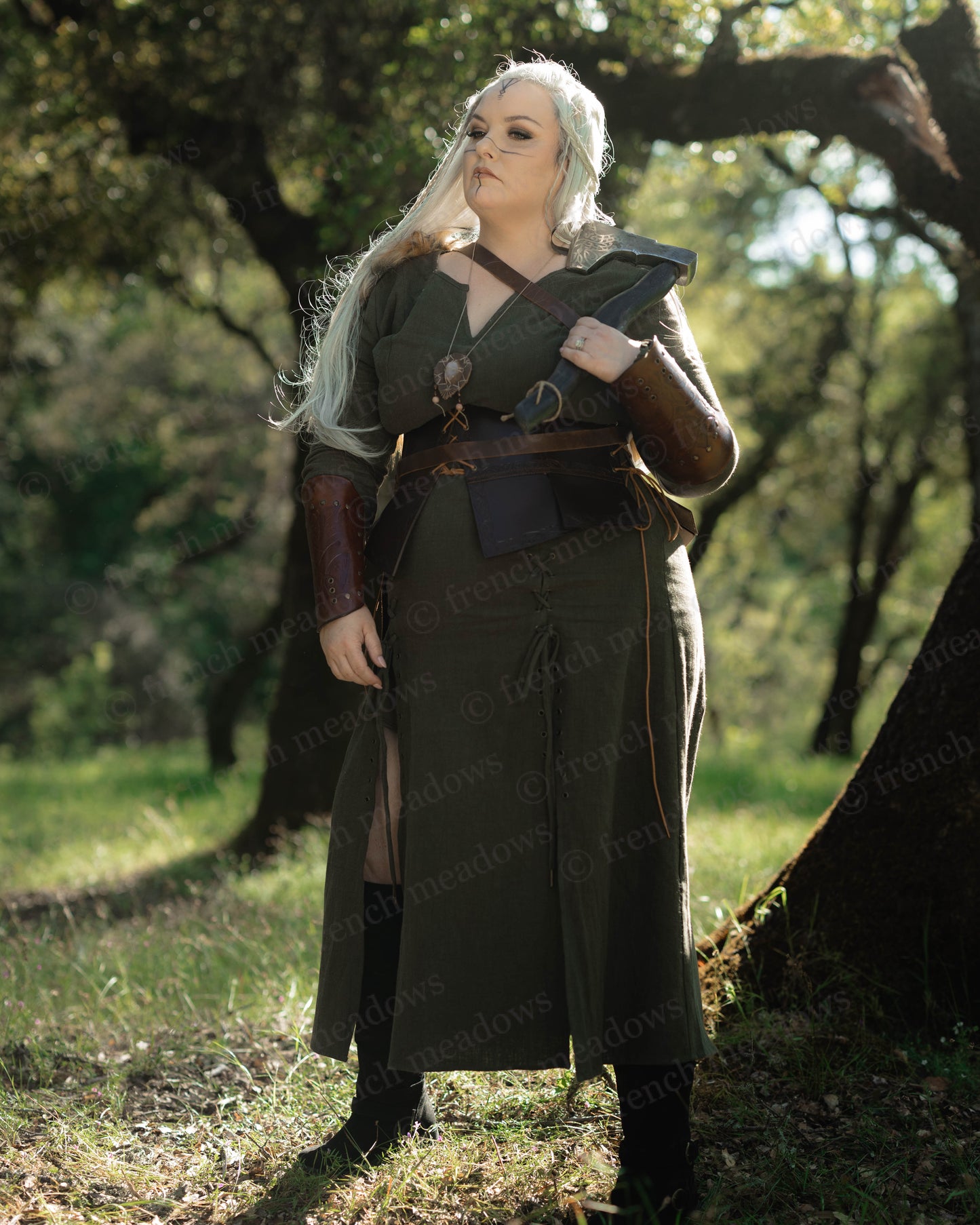 Olive Green Viking Dress worn outdoors, featuring pointed sleeves, front lacing, and a fitted silhouette.