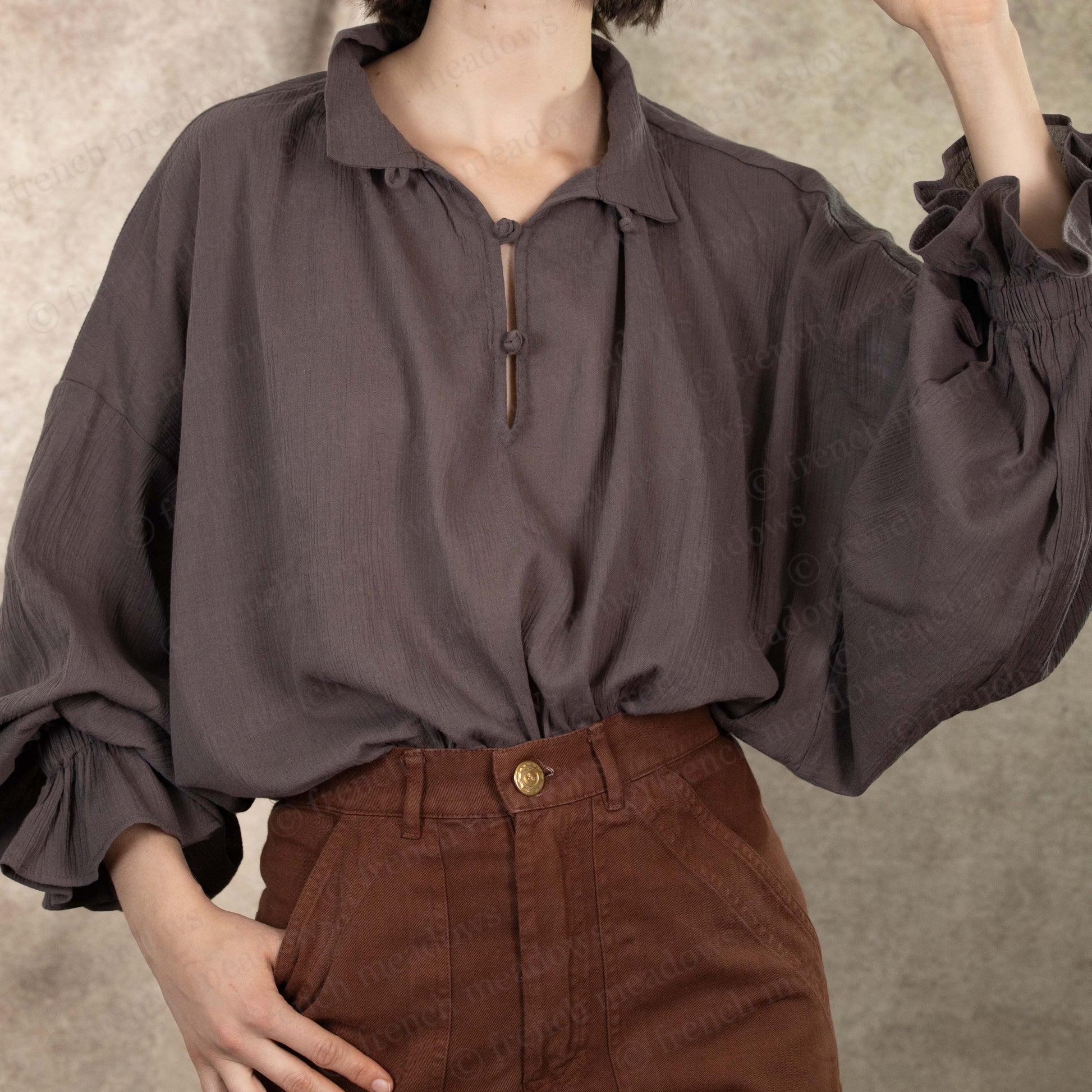 Darcy Shirt in charcoal gray cotton with billowing poet sleeves and vintage-style button closure, paired with brown pants