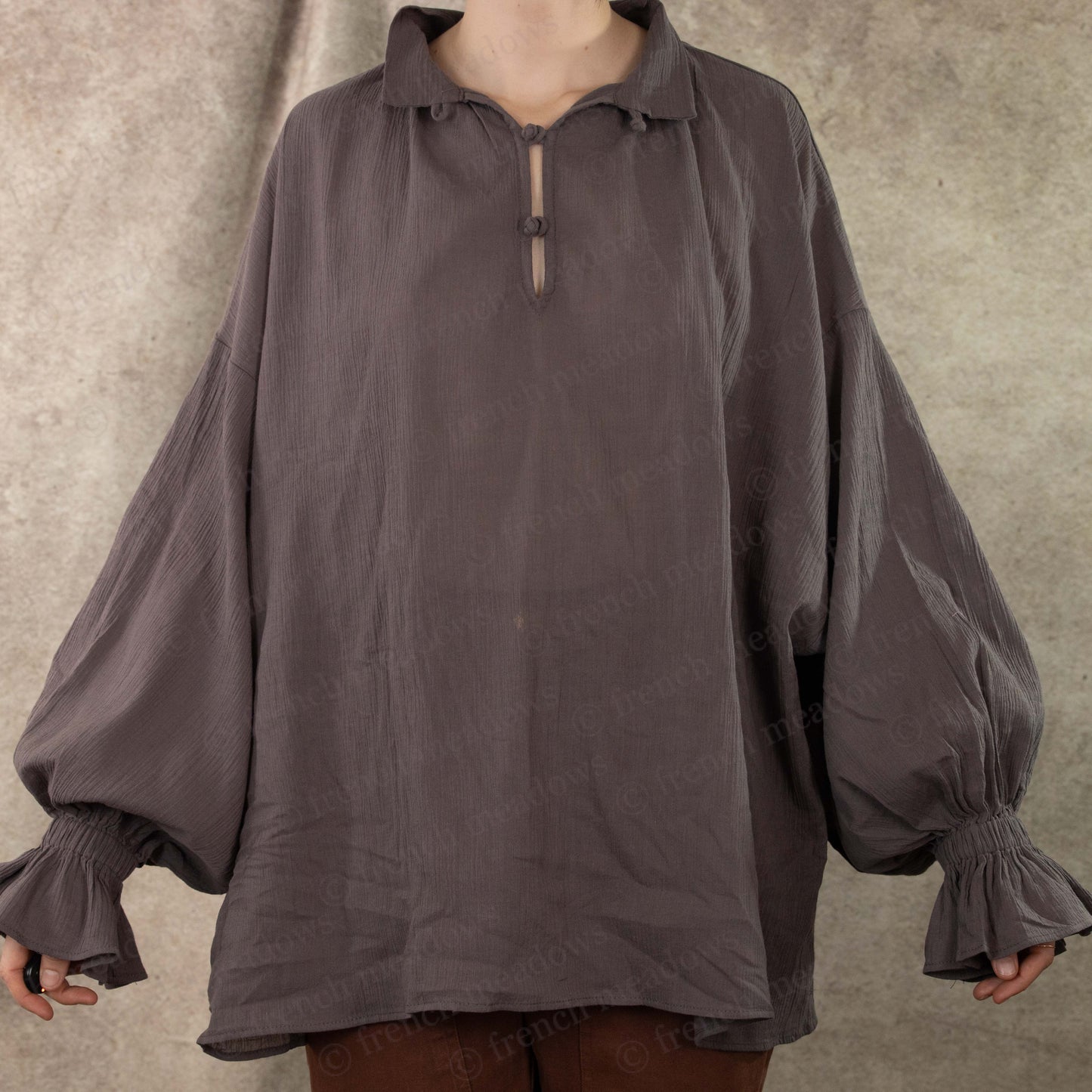 Darcy Shirt in charcoal gray with billowing poet sleeves and decorative knotted closure at collar, shown on mannequin