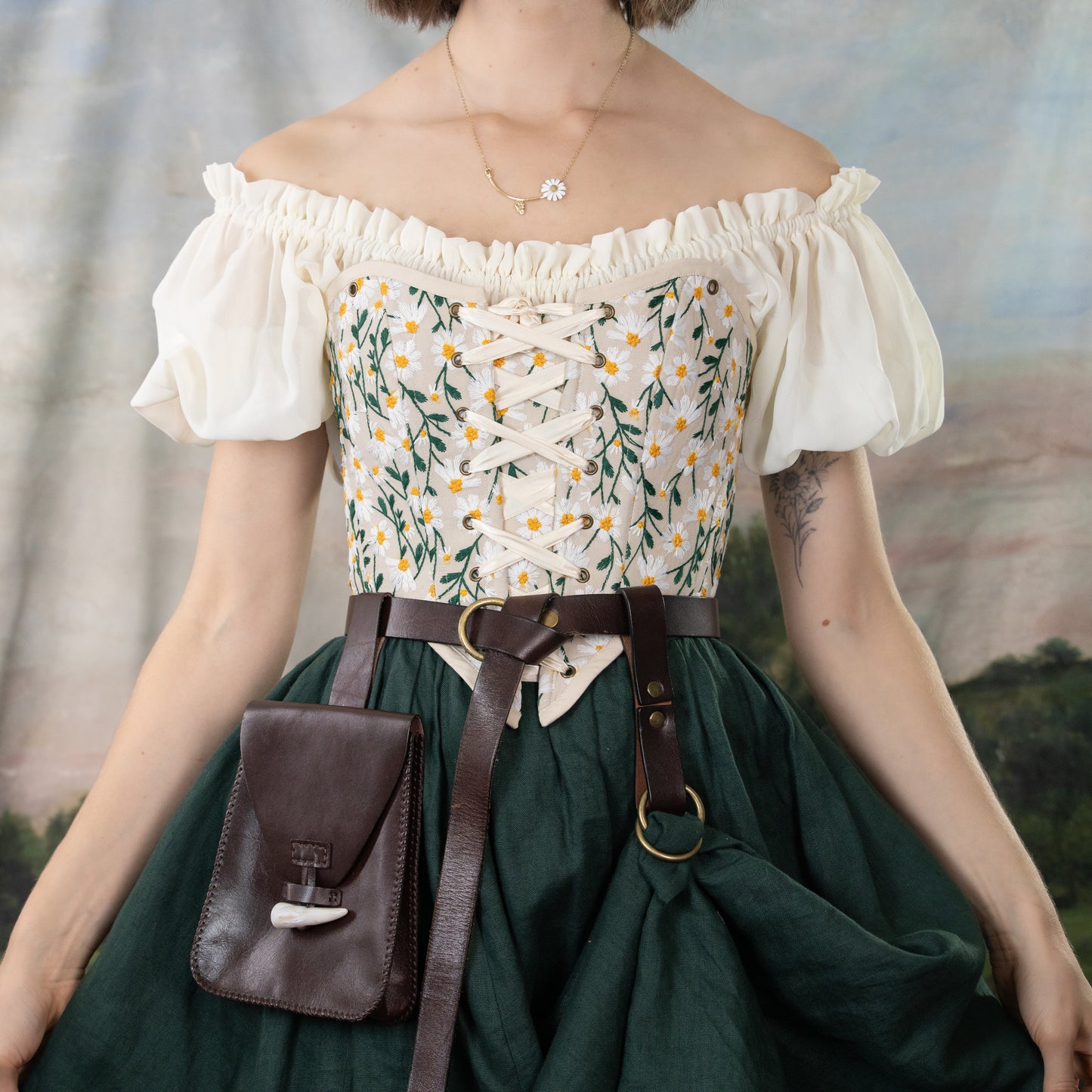 Embroidered Daisies Corset Top with puff sleeves and lace-up front, featuring yellow floral embroidery on white cotton bodice