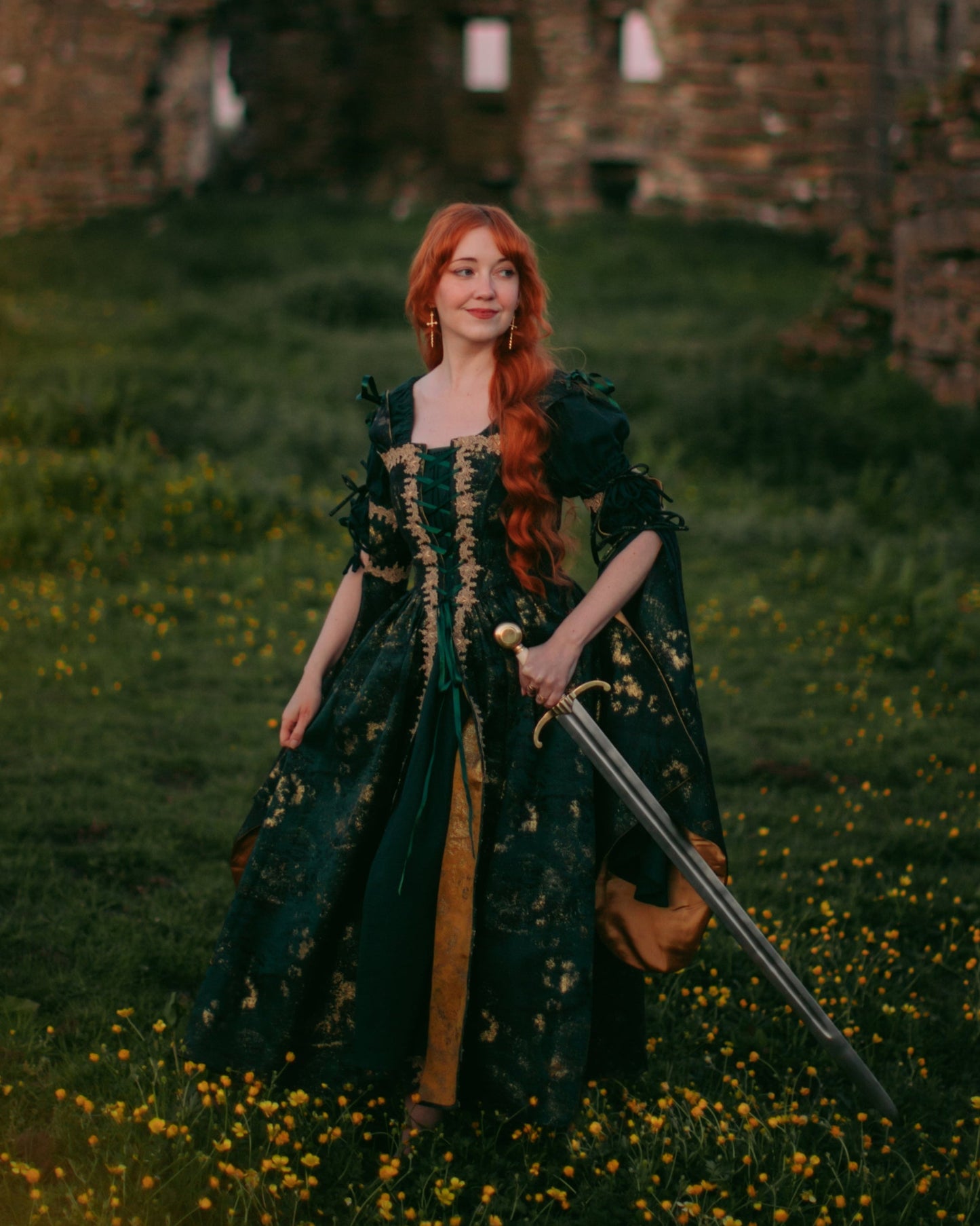 Dark Green Jacquard Corset Dress with gold accents, adjustable lacing, and removable bell sleeves in a medieval outdoor setting.