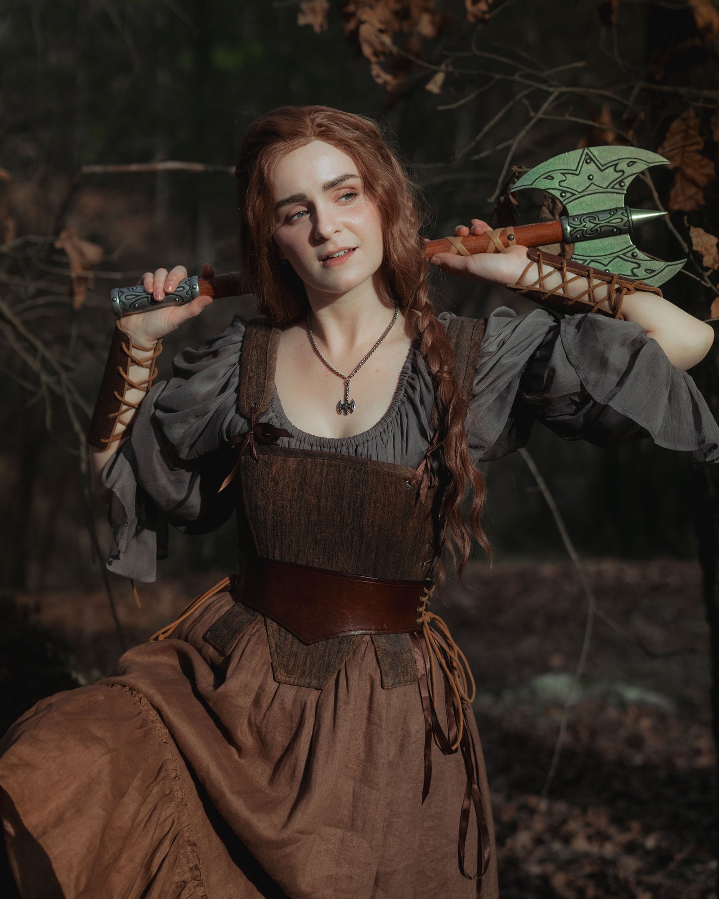 Brown Tabbed Tudor Stays shown in historical fantasy setting with medieval dress and decorative green battle axe prop
