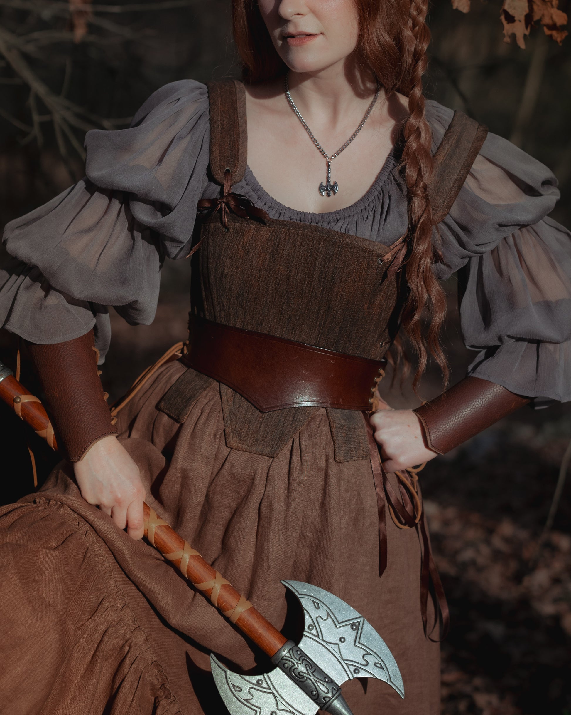 Brown Tabbed Tudor Stays shown on medieval costume with puff sleeves, leather belt and decorative battle axe accessory