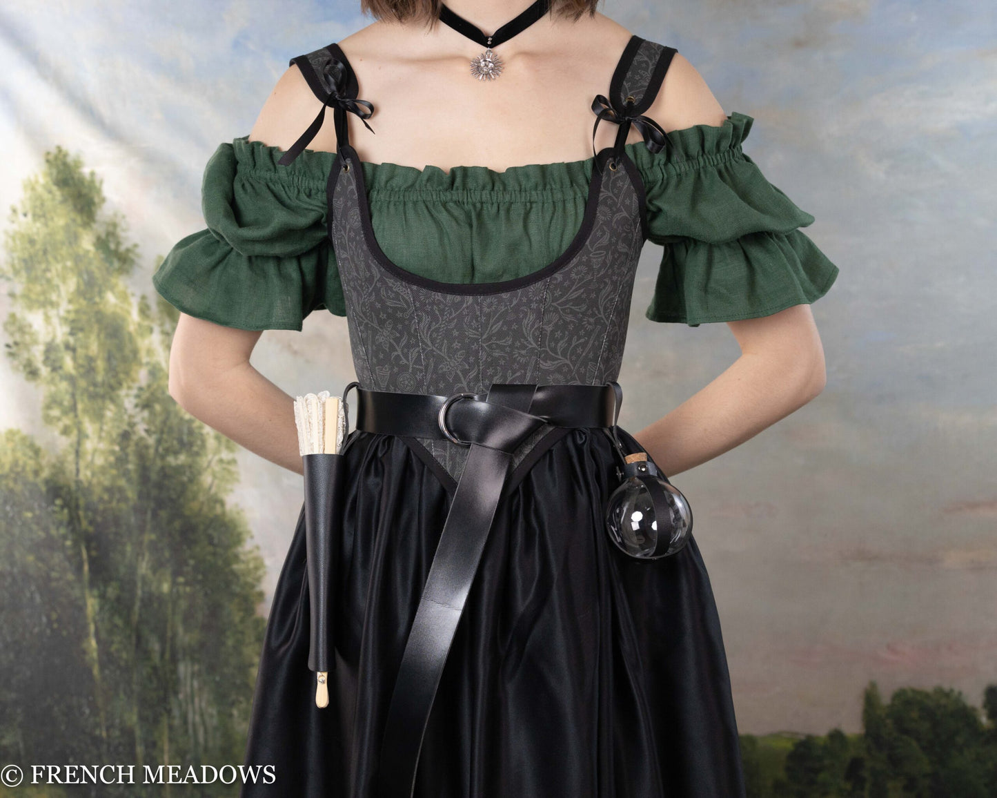 Fan Holster, black vegan leather carrying case with attached folded fan shown on Renaissance dress with green sleeves and dark bodice
