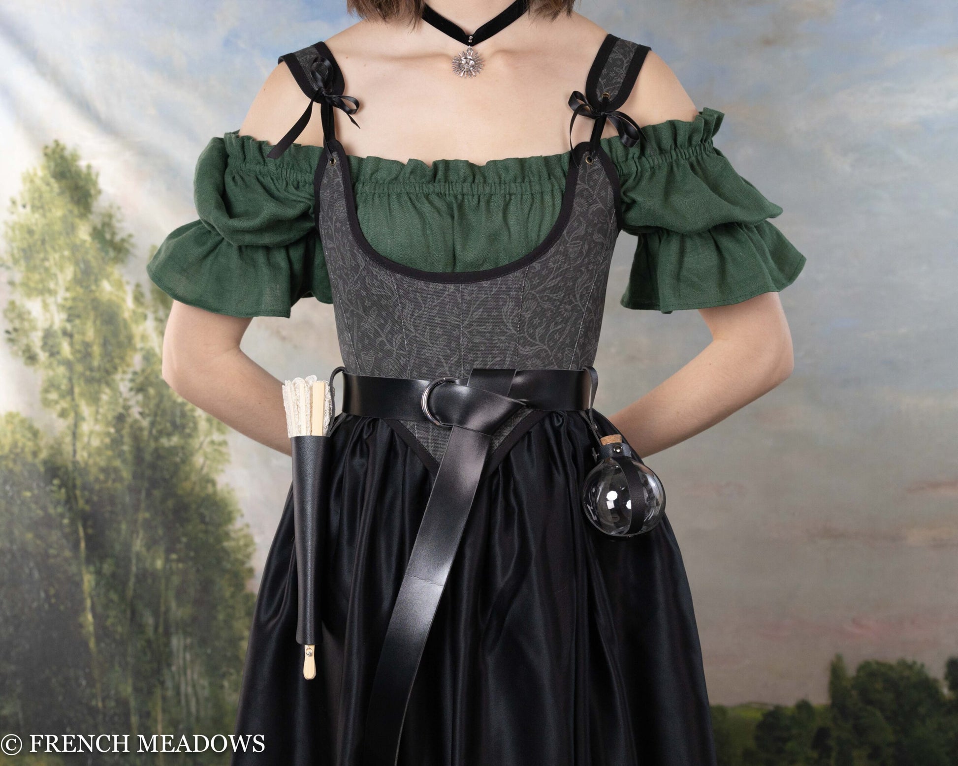 Fan Holster, black vegan leather carrying case with attached folded fan shown on Renaissance dress with green sleeves and dark bodice