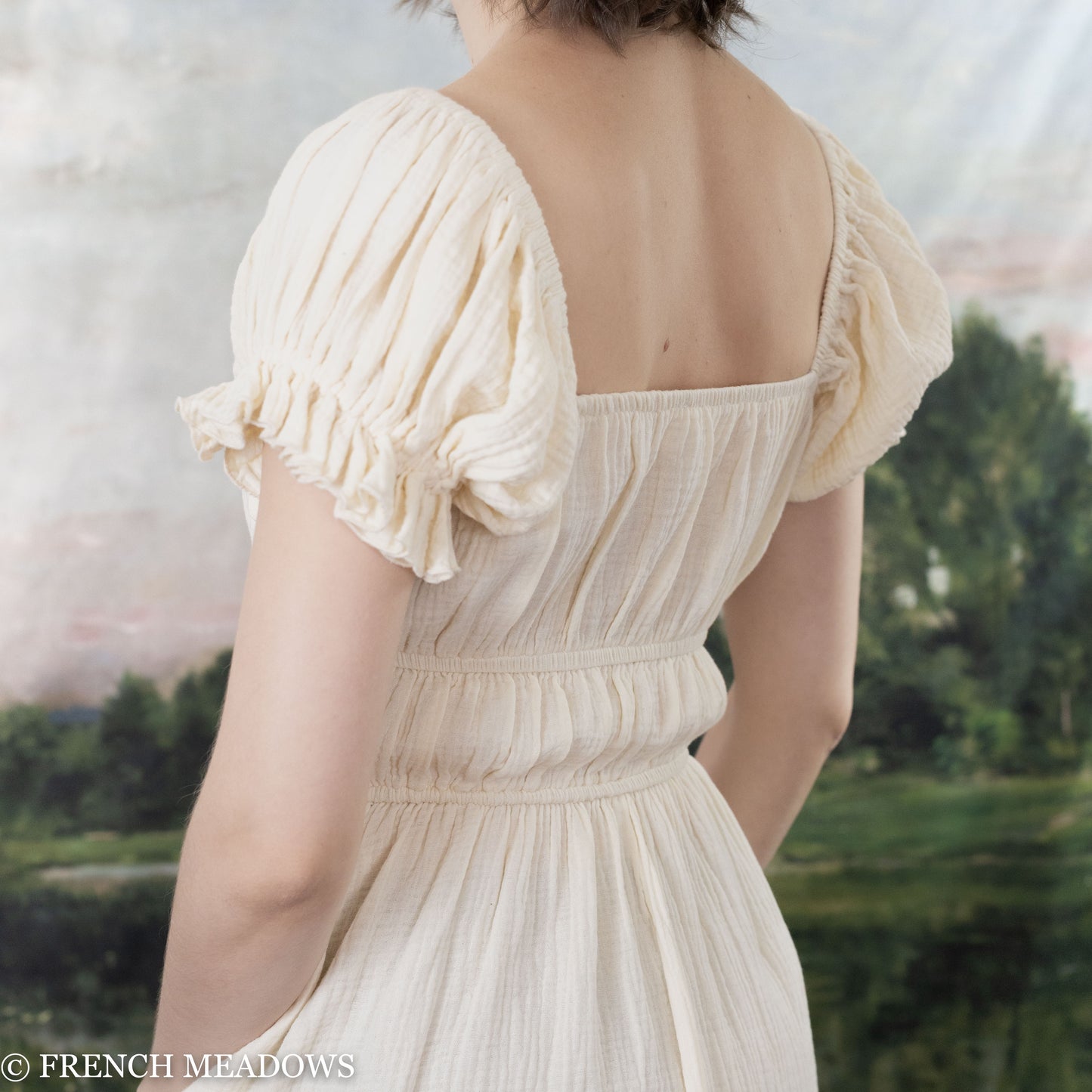 back view of model wearing an ivory cotton milkmaid dress