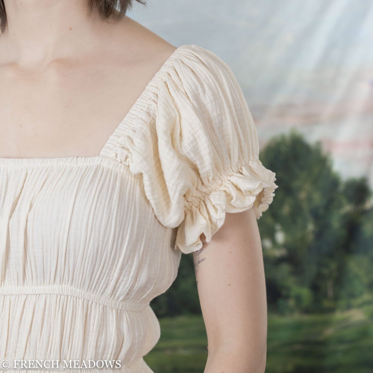 detail view of elasticized puff sleeves on the ivory cotton romantic dress