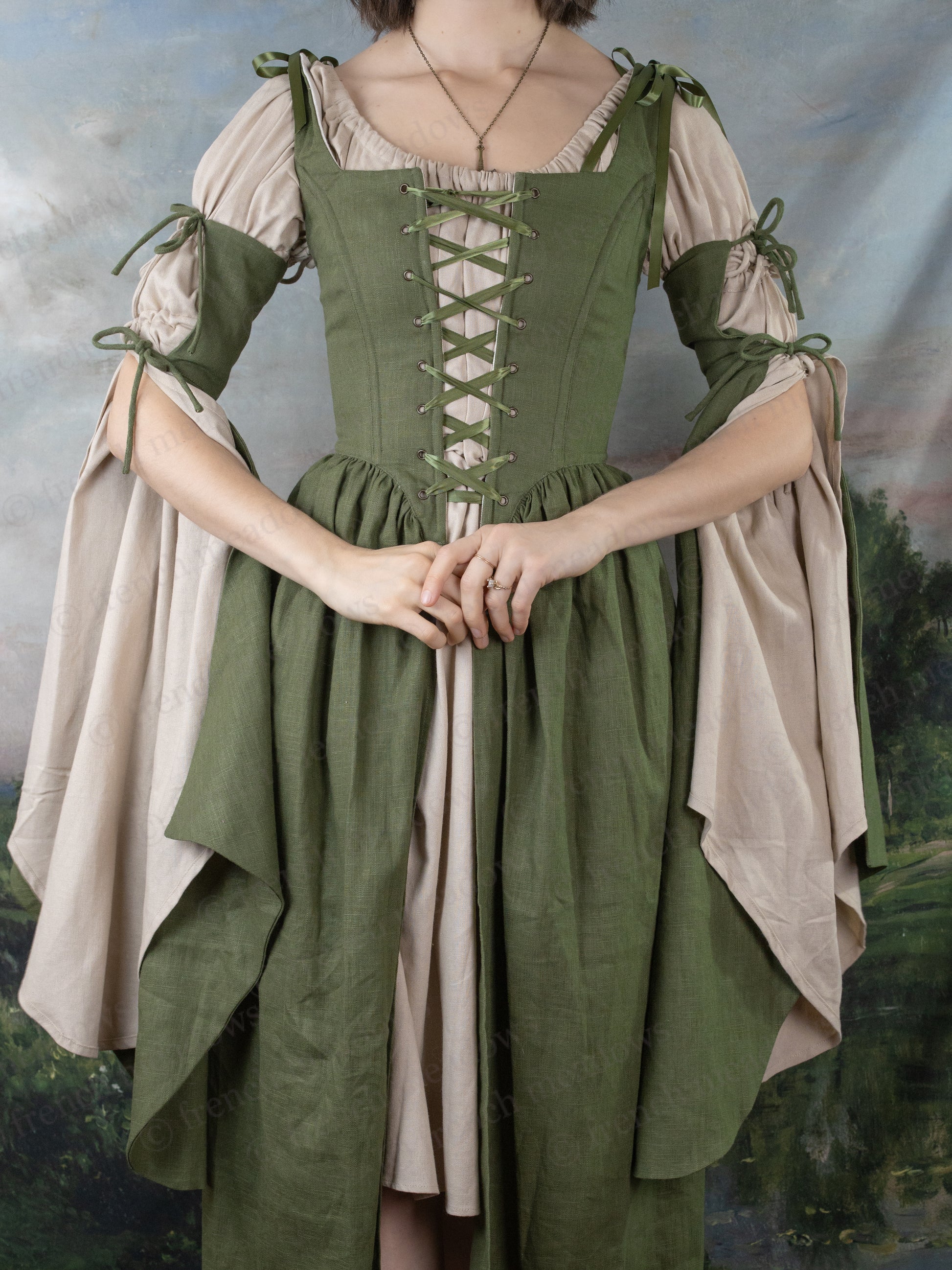 Ivy Green Corset Dress with laced bodice, flowing bell sleeves, and cream underdress in medieval fantasy style