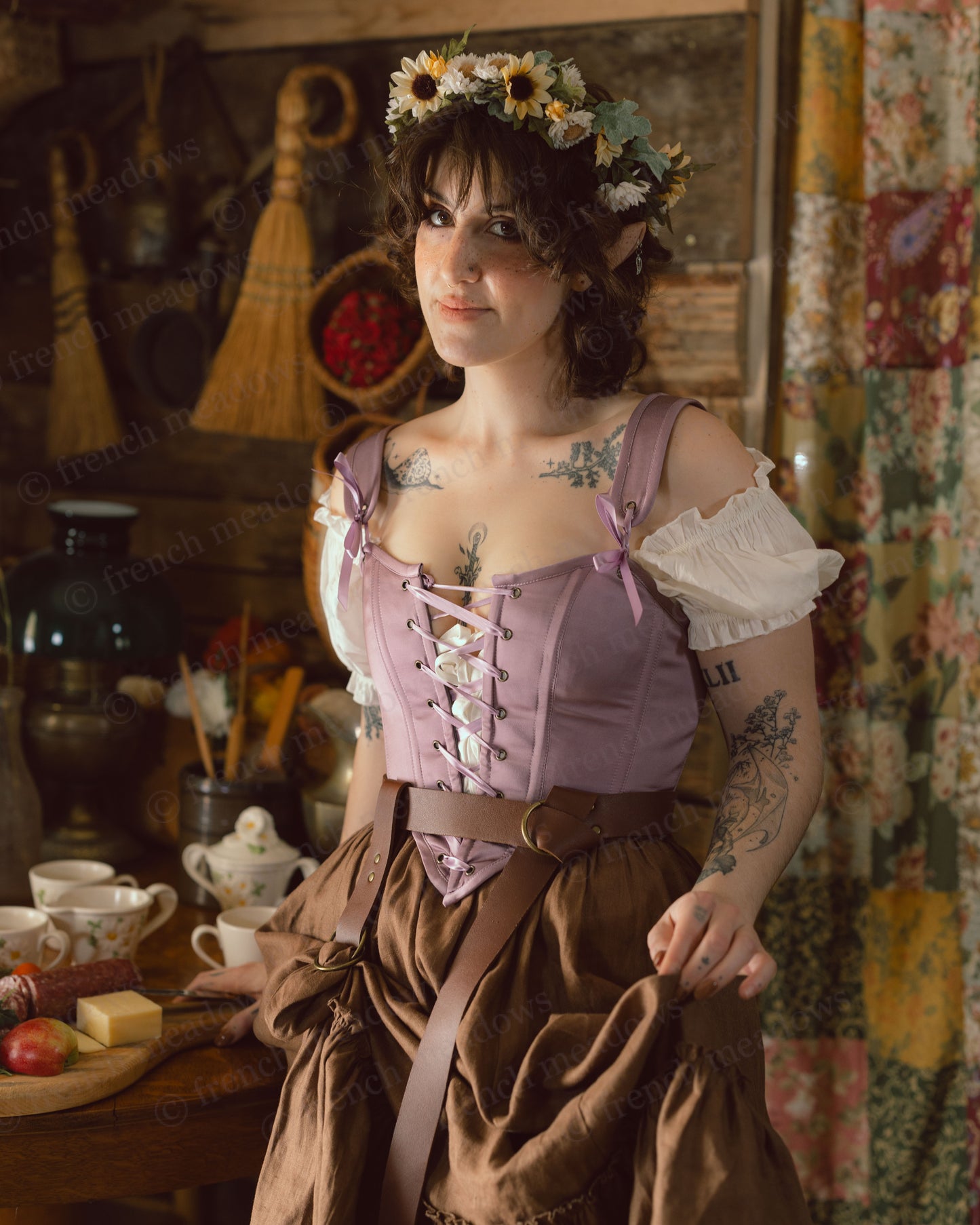 Purple Dusk Satin Corset Top styled with brown skirt and white daisy crown in rustic cottage setting with vintage tea service