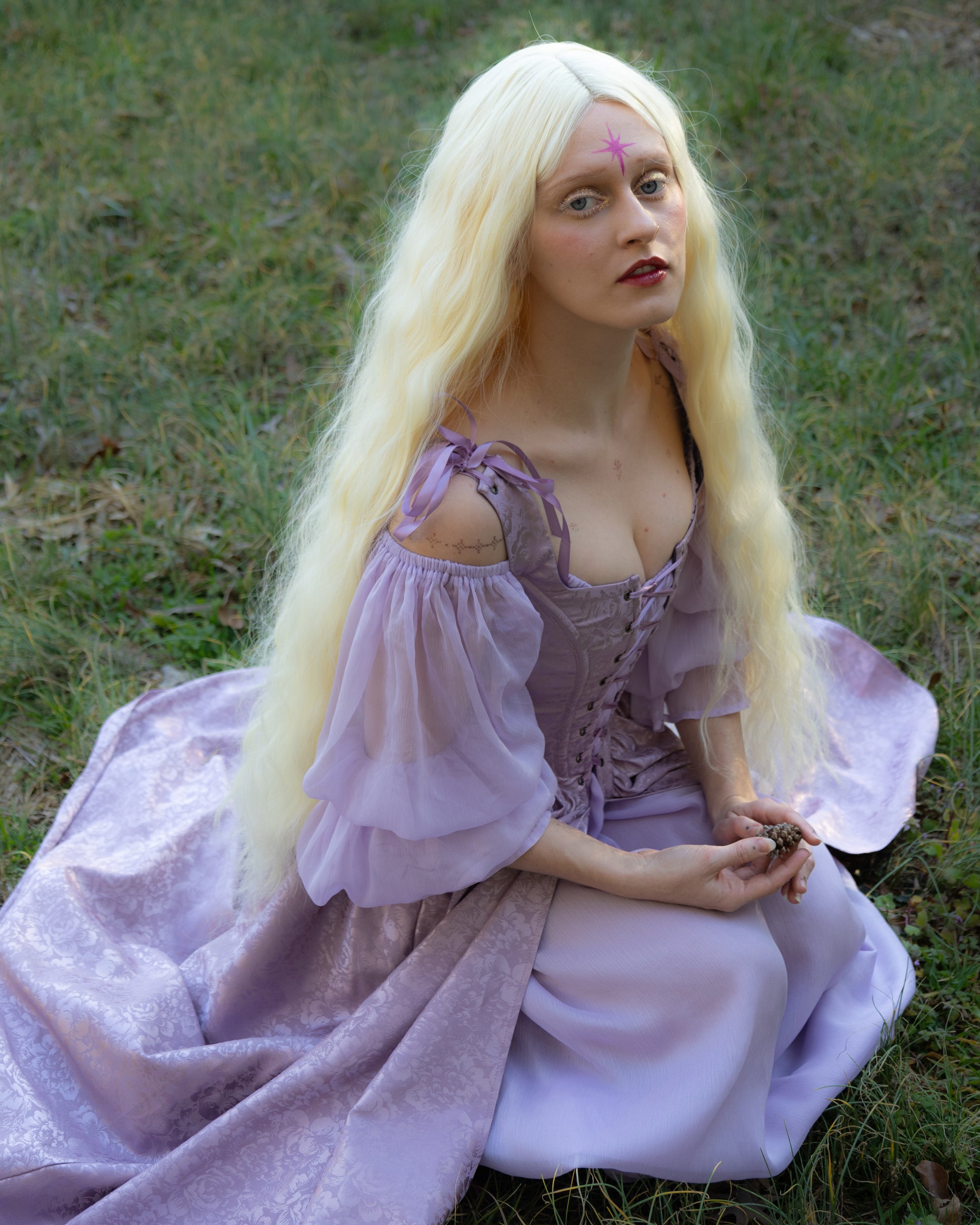 Lavender Floral Satin Corset Dress shown outdoors on grassy background, featuring lace-up bodice and flowing skirt with shimmering fabric