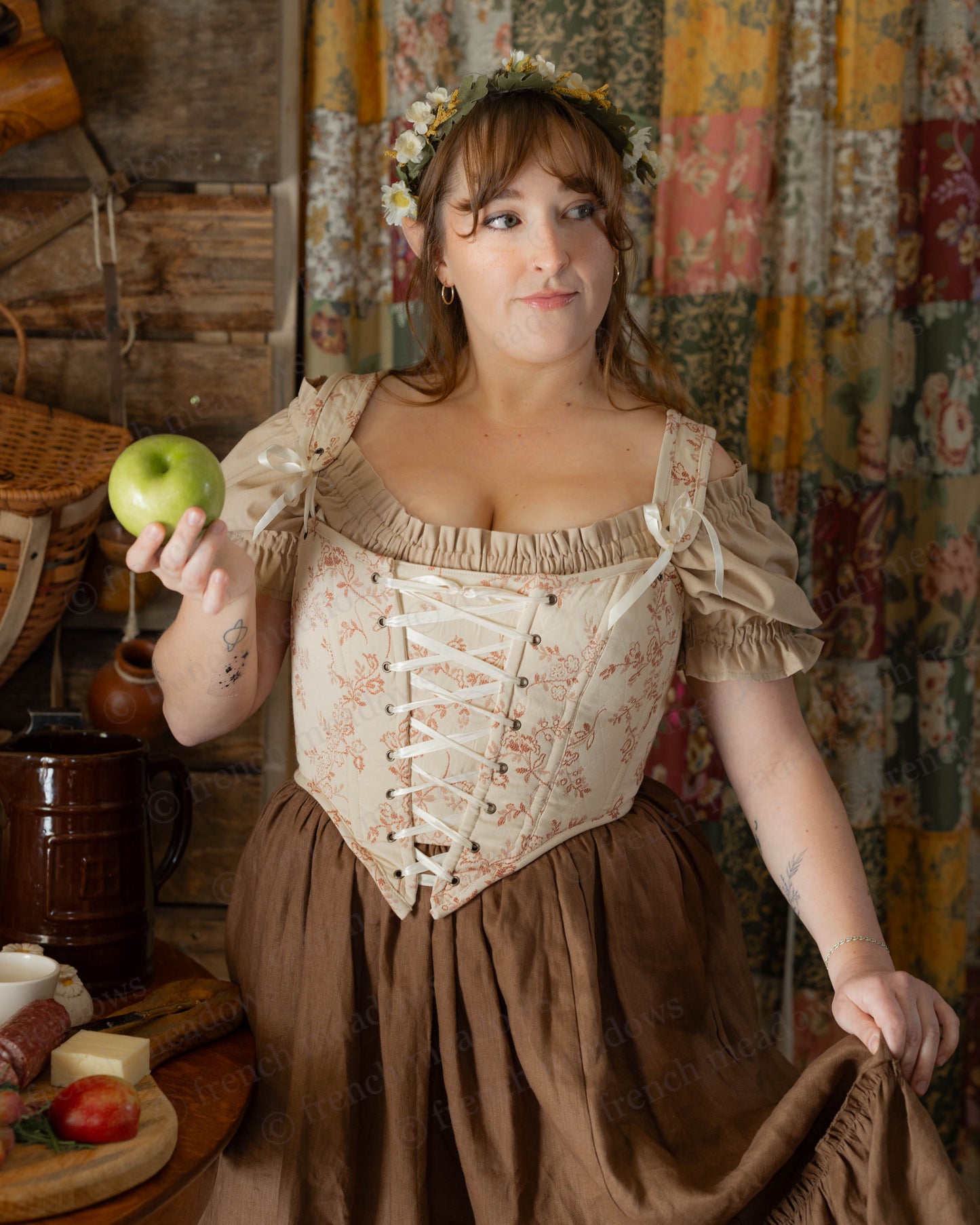 Rosey Ivory Floral Corset Top with lace-up front and puff sleeves shown in fairy tale cottage setting against vintage curtains