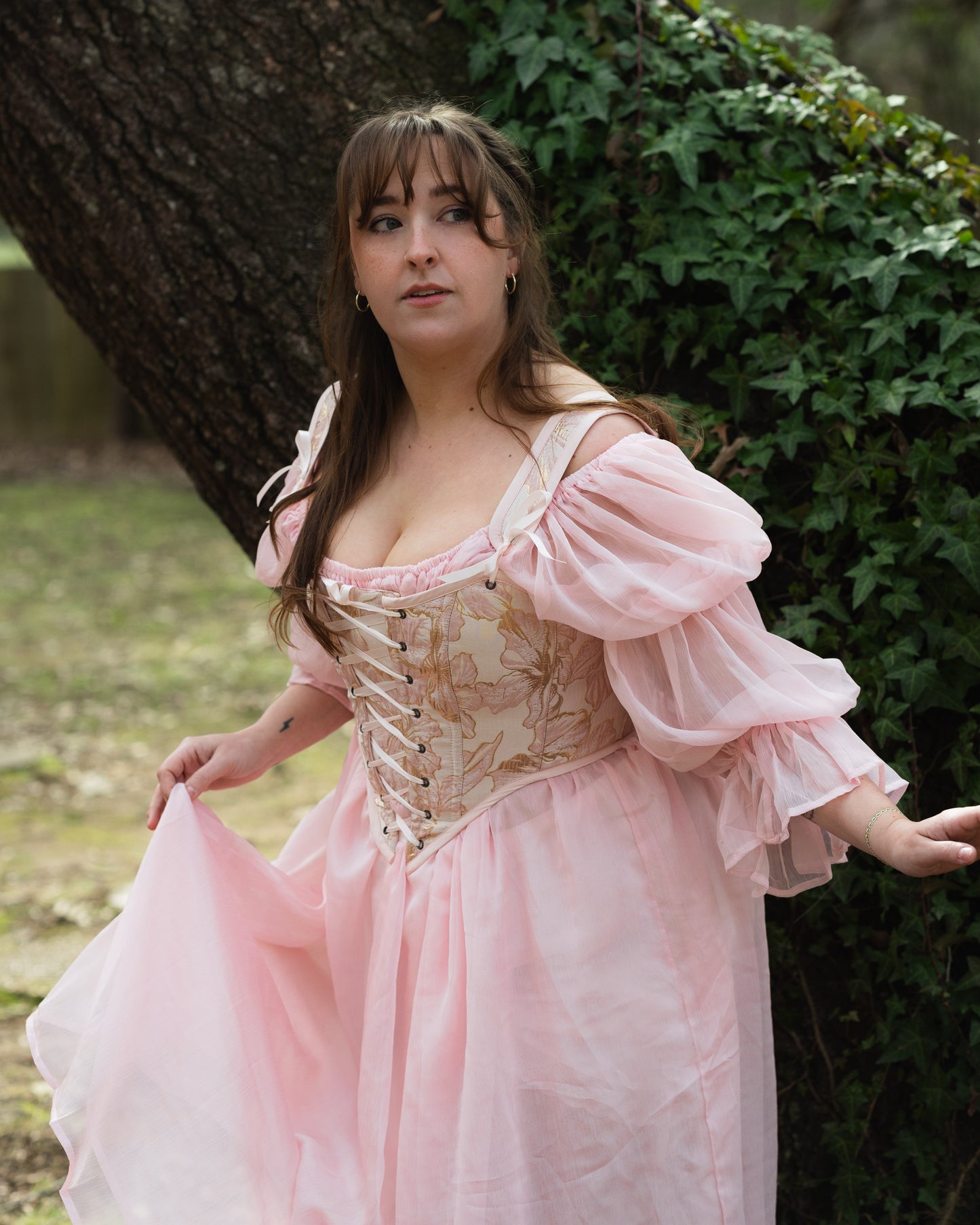 Pink and Gold Metallic Floral Corset Top with Renaissance-style bodice featuring gold floral patterns and puffy pink sleeves in outdoor setting