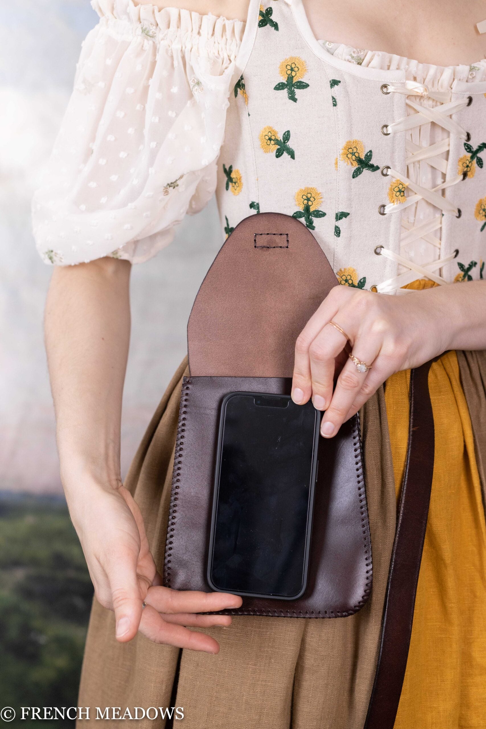 Leather Belt Pouch shown on person in historical costume, demonstrating phone fitting inside brown leather medieval-style pouch