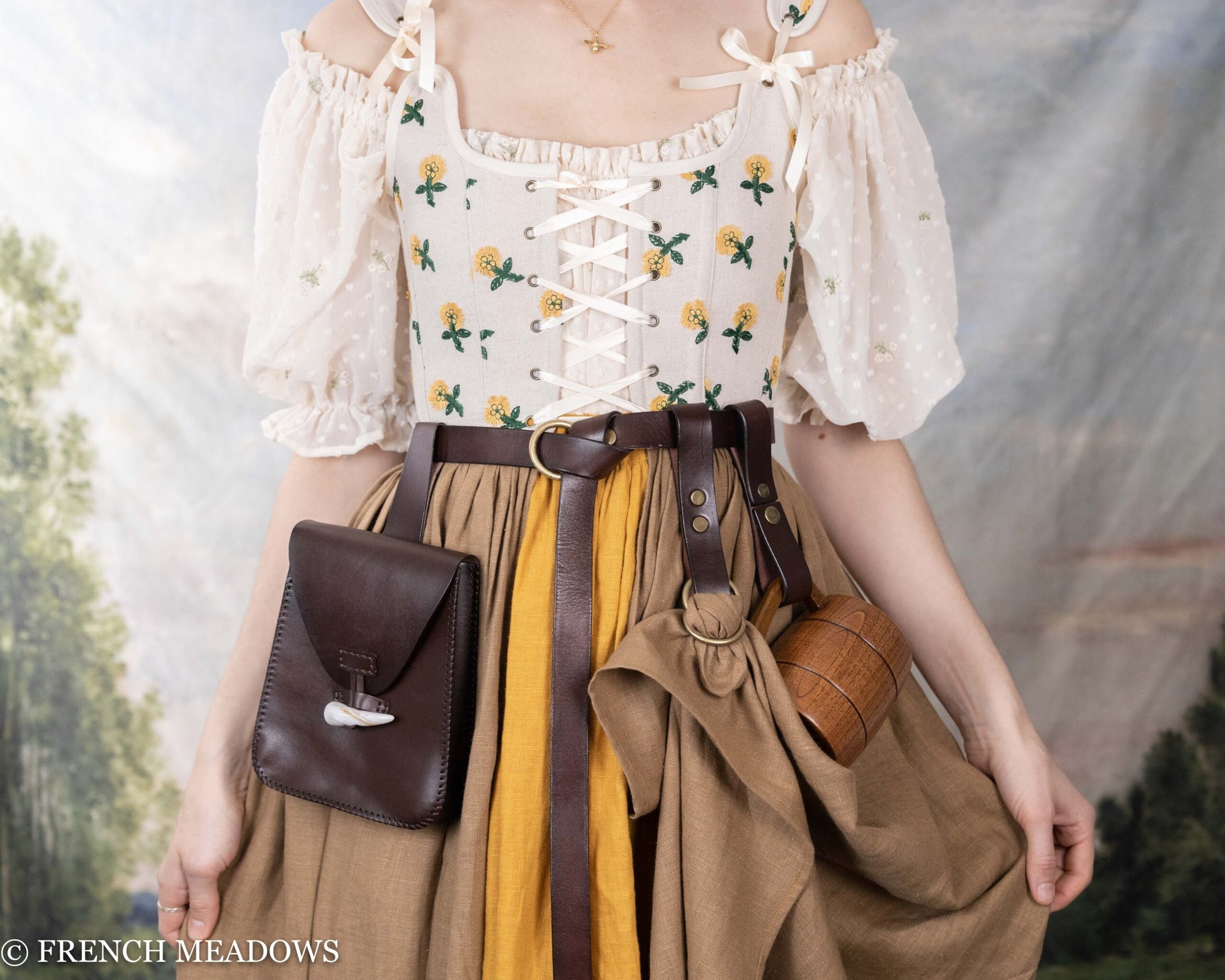 Brown leather belt pouch worn with medieval costume featuring floral corset and yellow skirt, perfect for renaissance faire