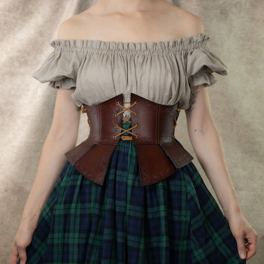 Debossed leather underbust corset with medieval pattern, paired with white peasant top and plaid skirt in green tartan