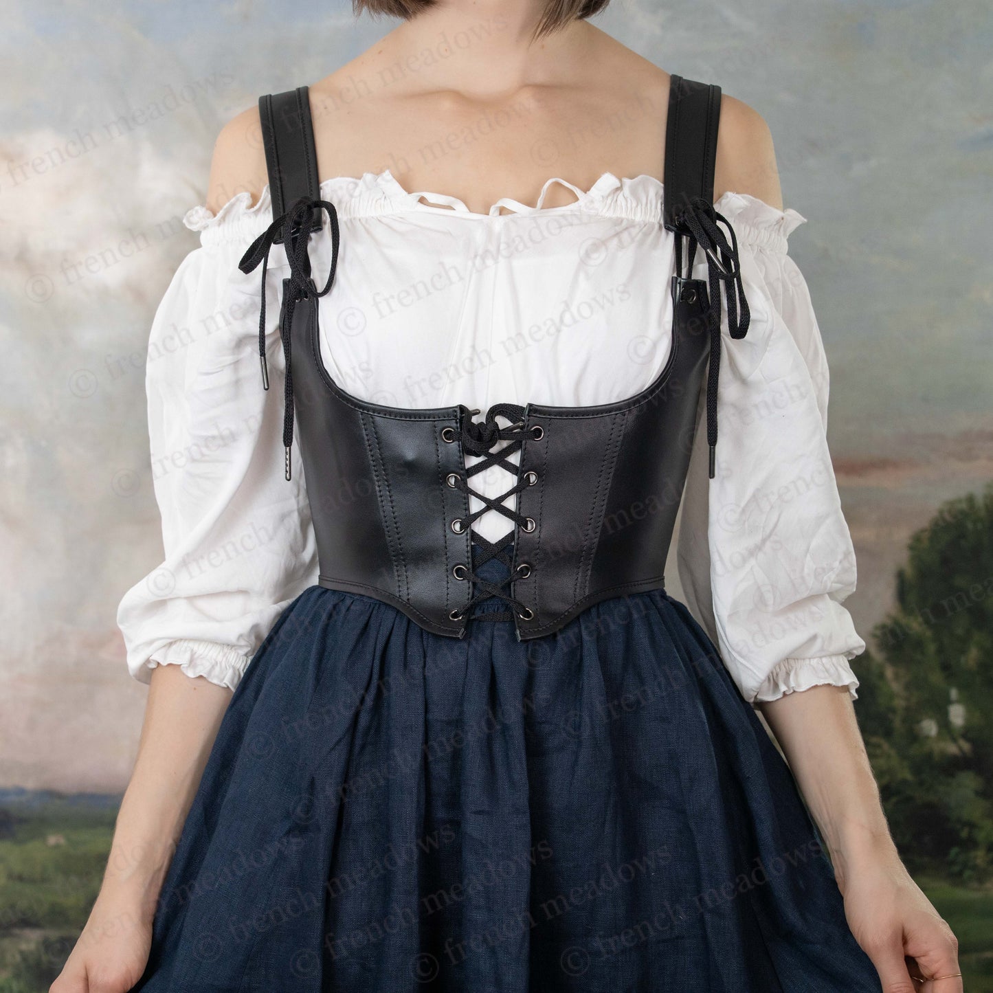 Leather underbust corset belt shown with white peasant blouse and navy skirt in Renaissance-inspired styling